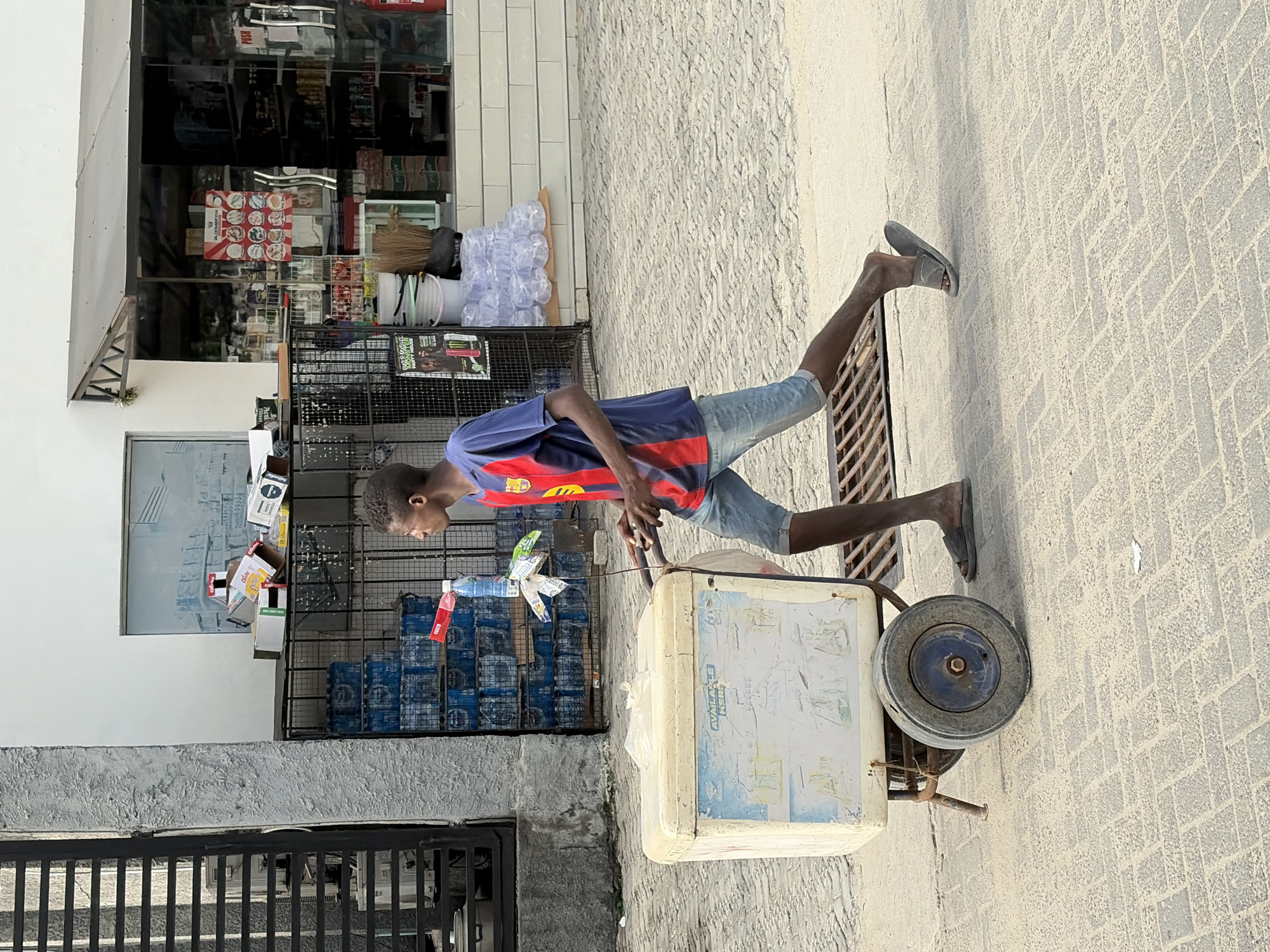 DHL van parks as man carries bamboo poles in Igboefon