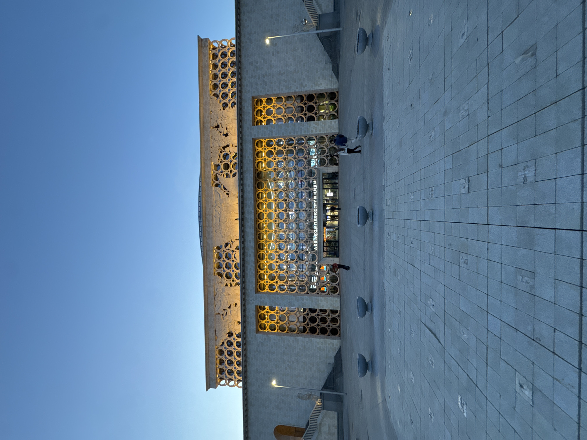 Moscow concert hall area documented with sculptures, unicyclist, architecture