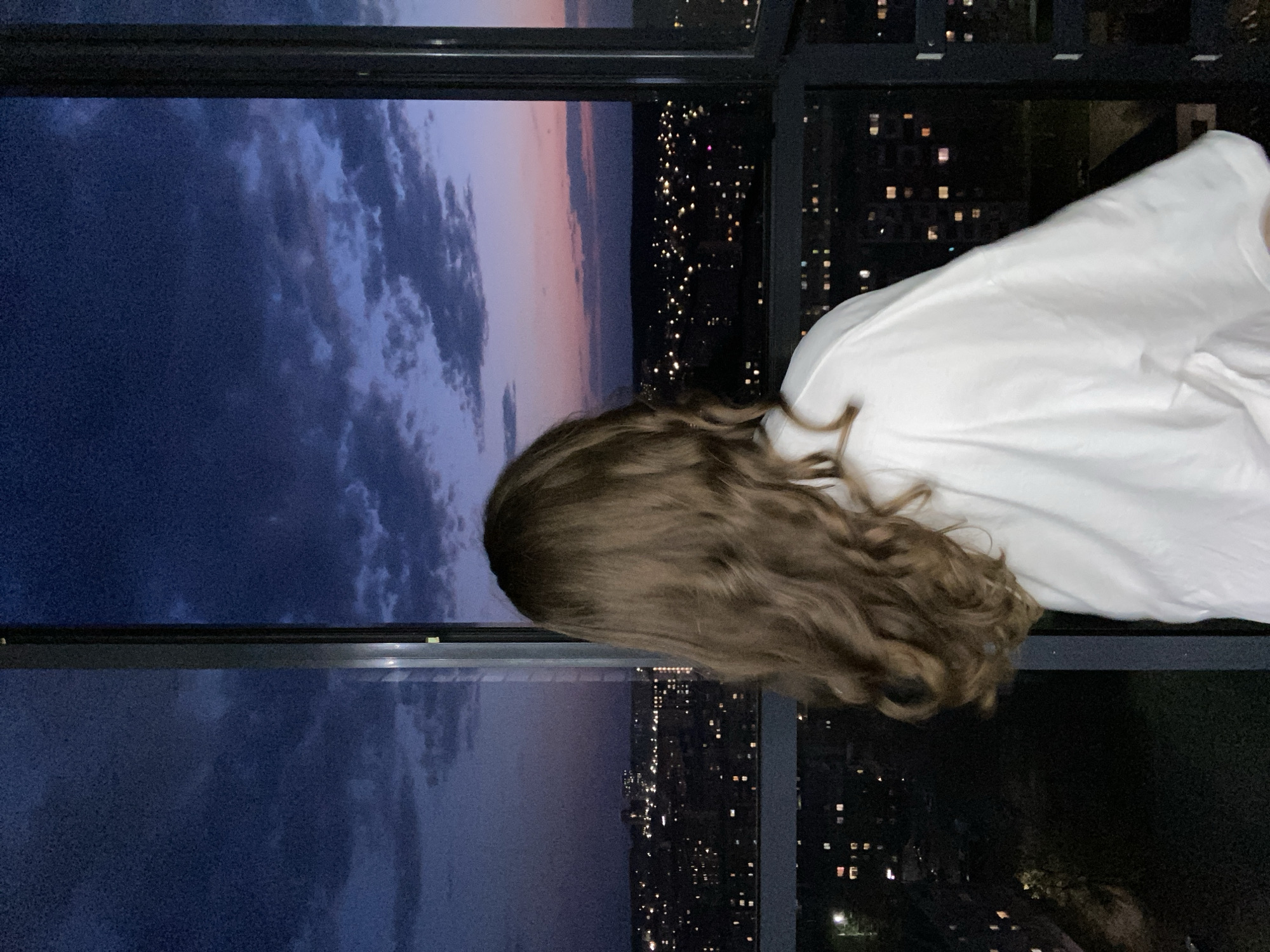 Woman takes selfies at window during sunset in Izhevsk