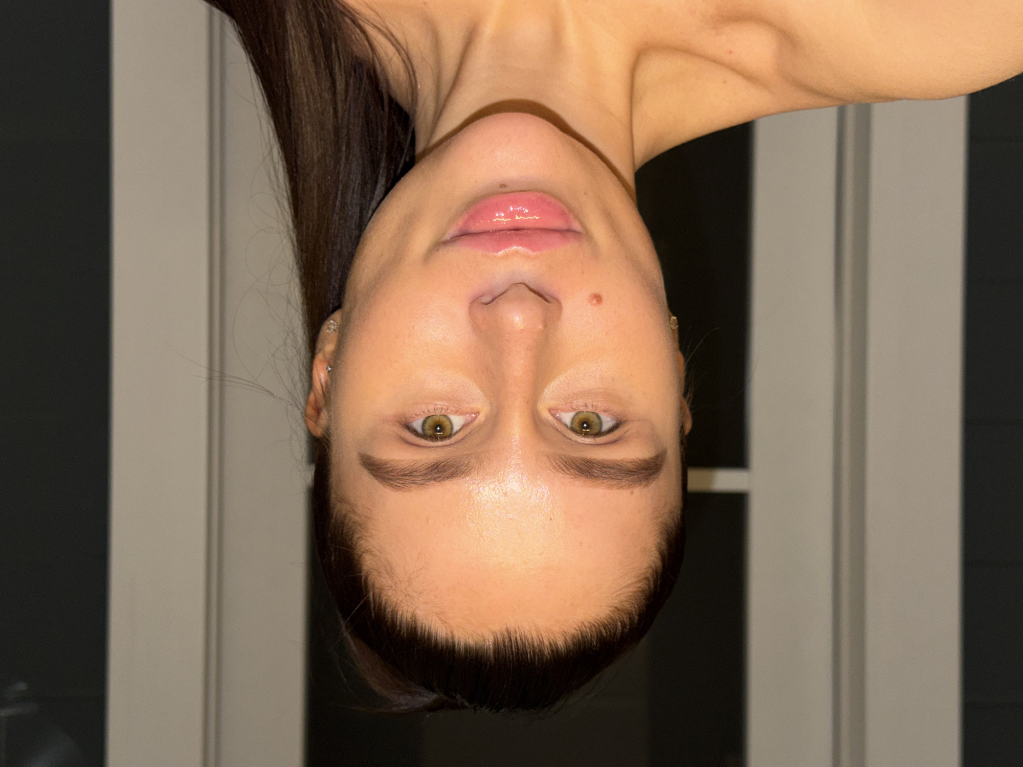 Woman takes bathroom selfies while holding water glass