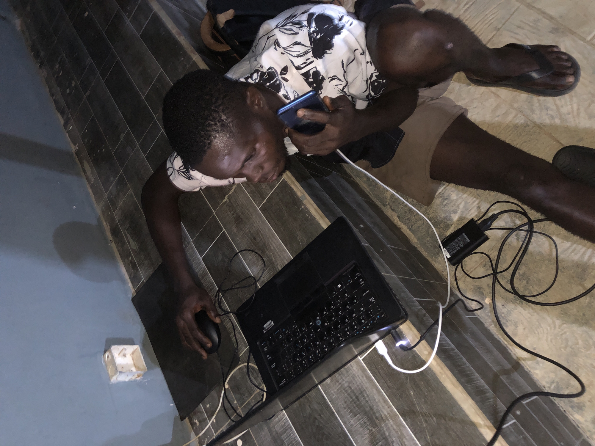 People using phones and laptops on tiled floors