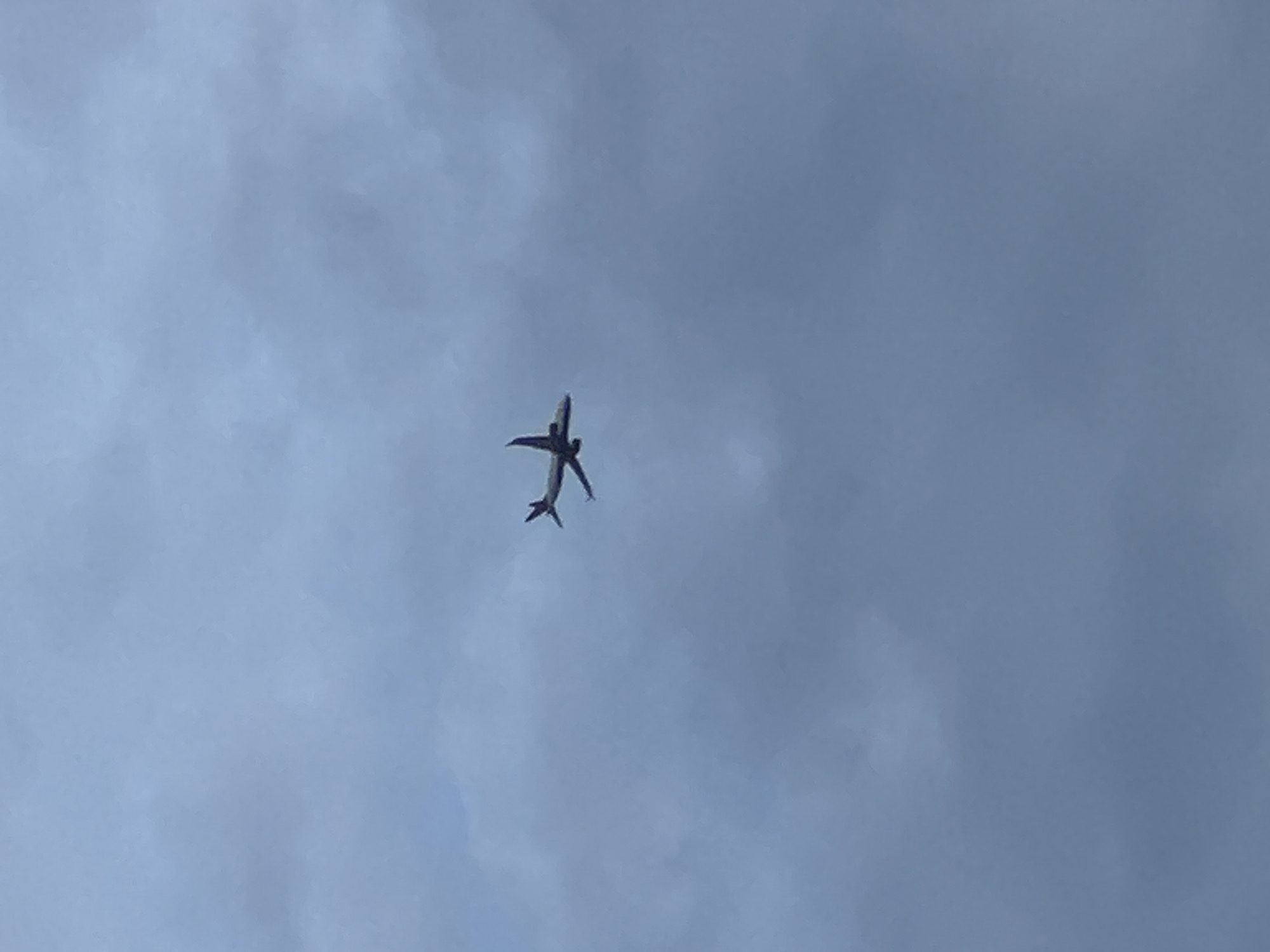 Passenger jet spotted overhead through cloudy skies over London