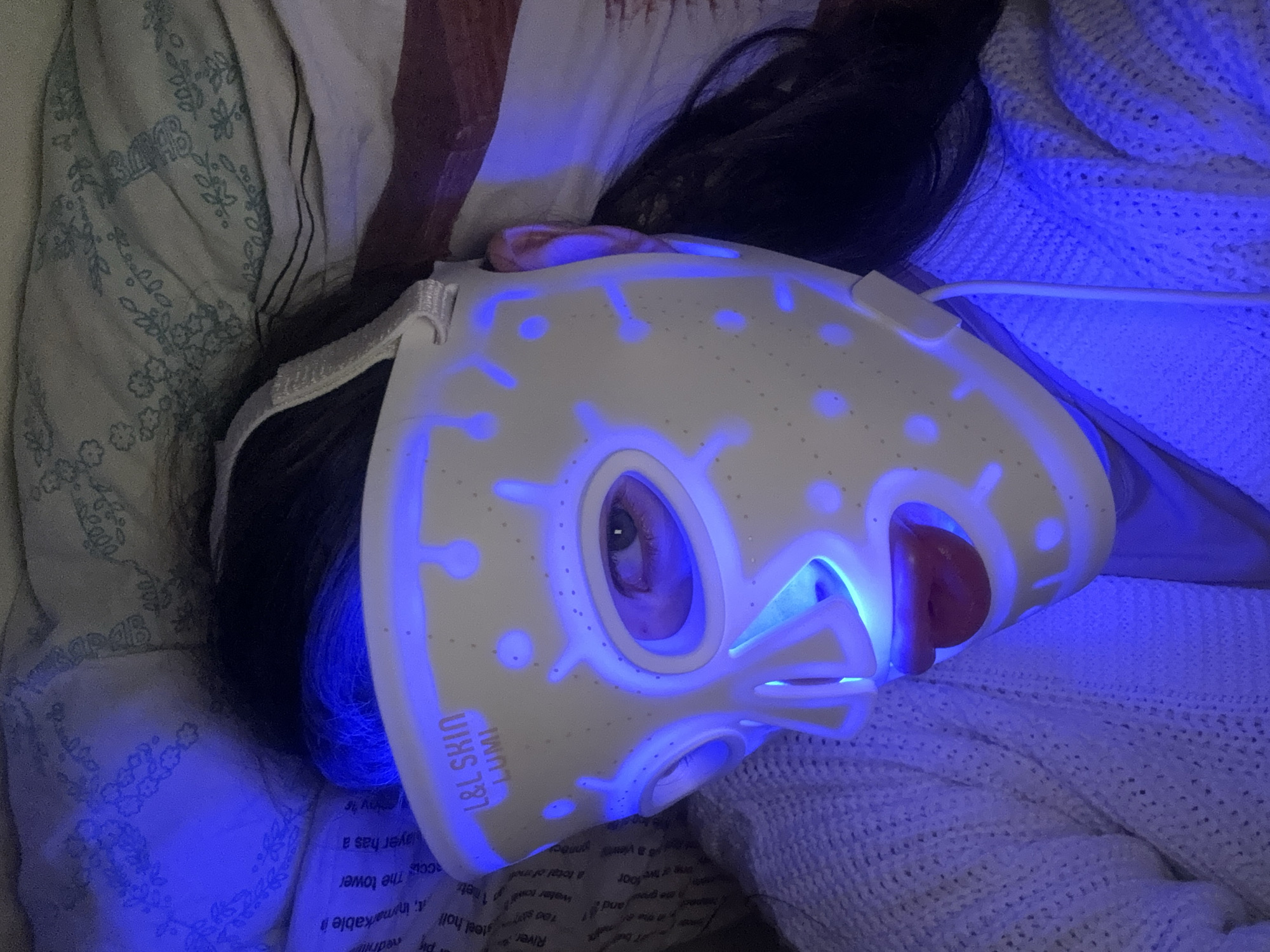 Woman rests in bed with tea during evening hours