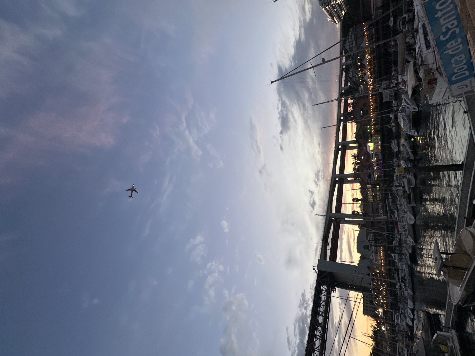 Lisbon marina at dusk, boats docked under a pastel evening sky