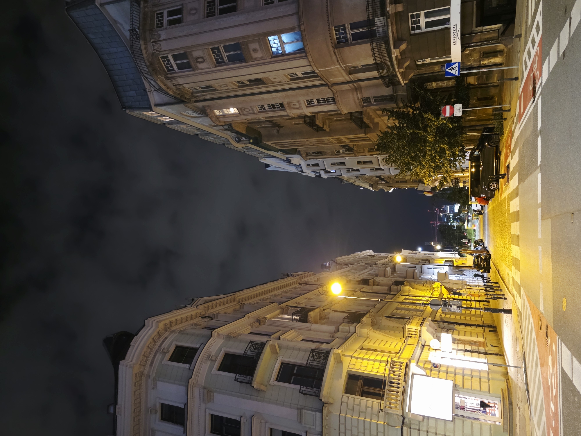 Late-night street scenes across central Warsaw's mixed architectural blocks
