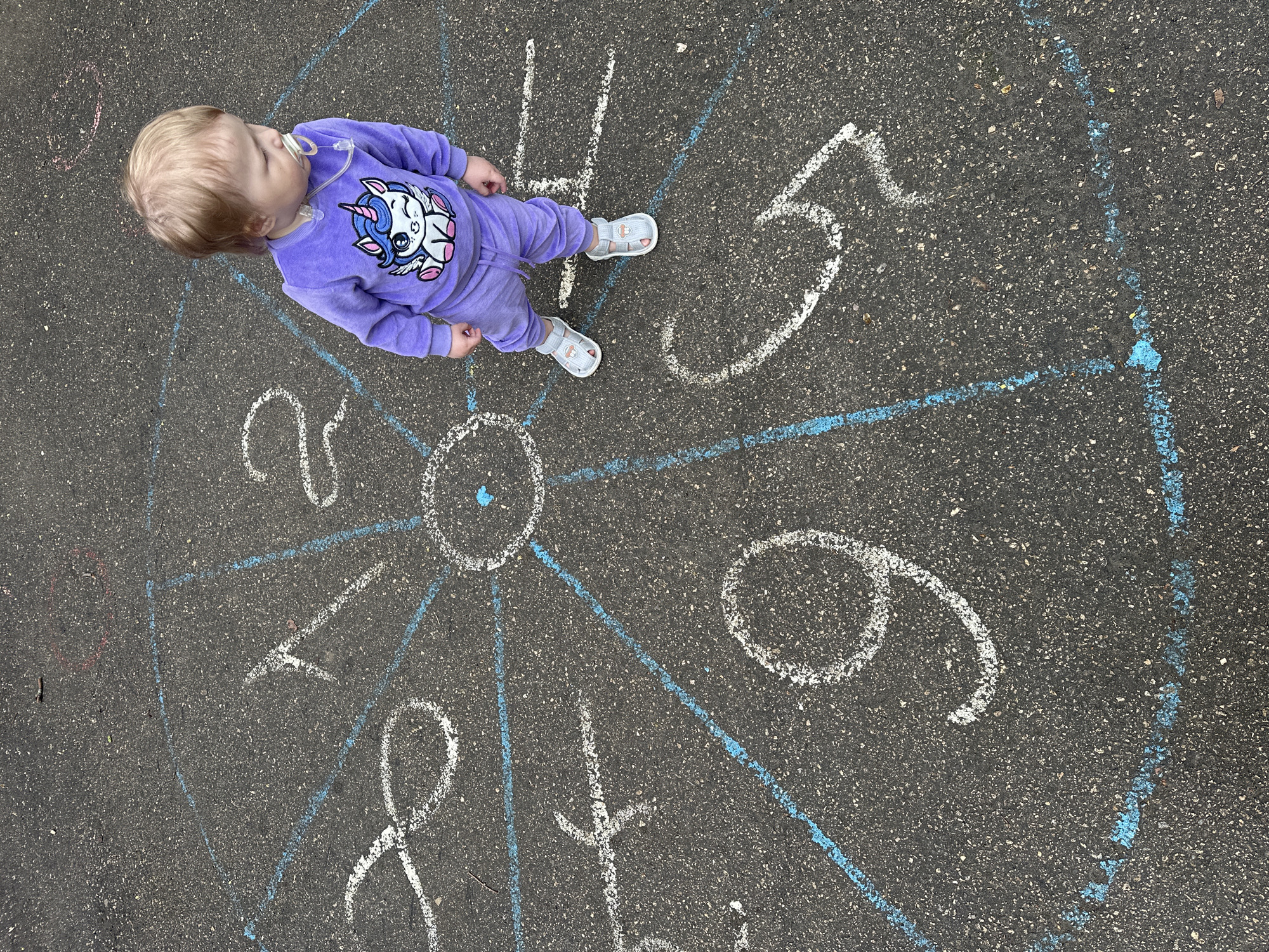 Child stands on chalk clock drawing in Nizhny Novgorod