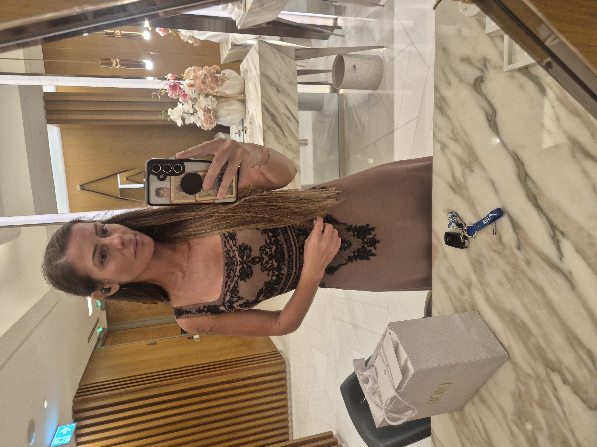 Woman takes mirror selfies in upscale indoor setting