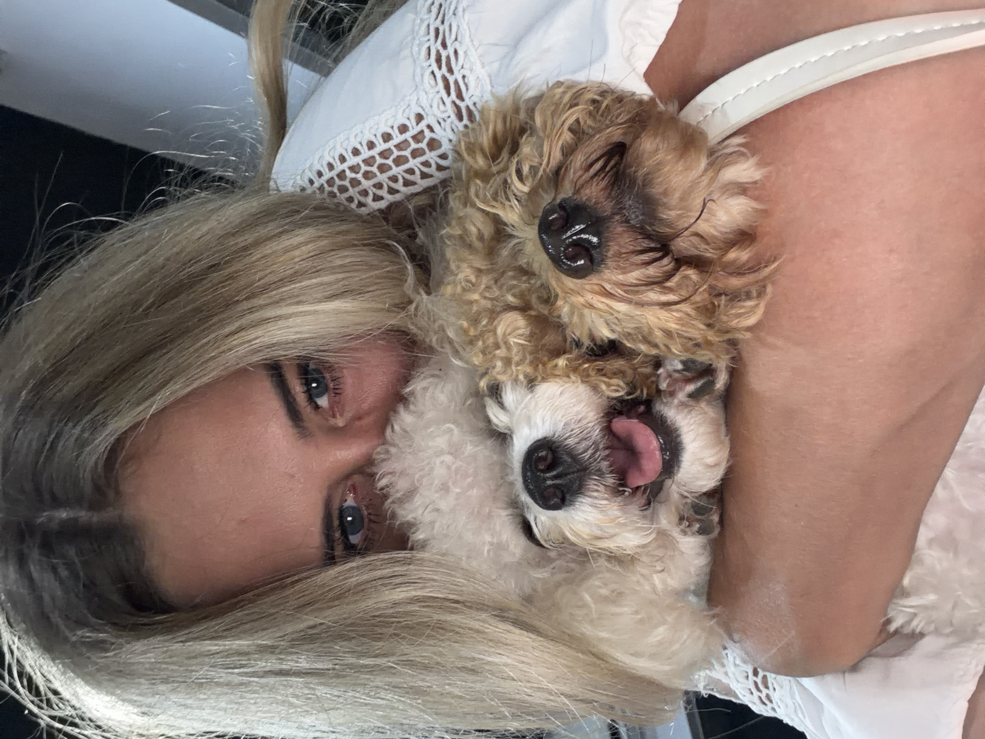 Woman holds white dog affectionately in Kedewatan home