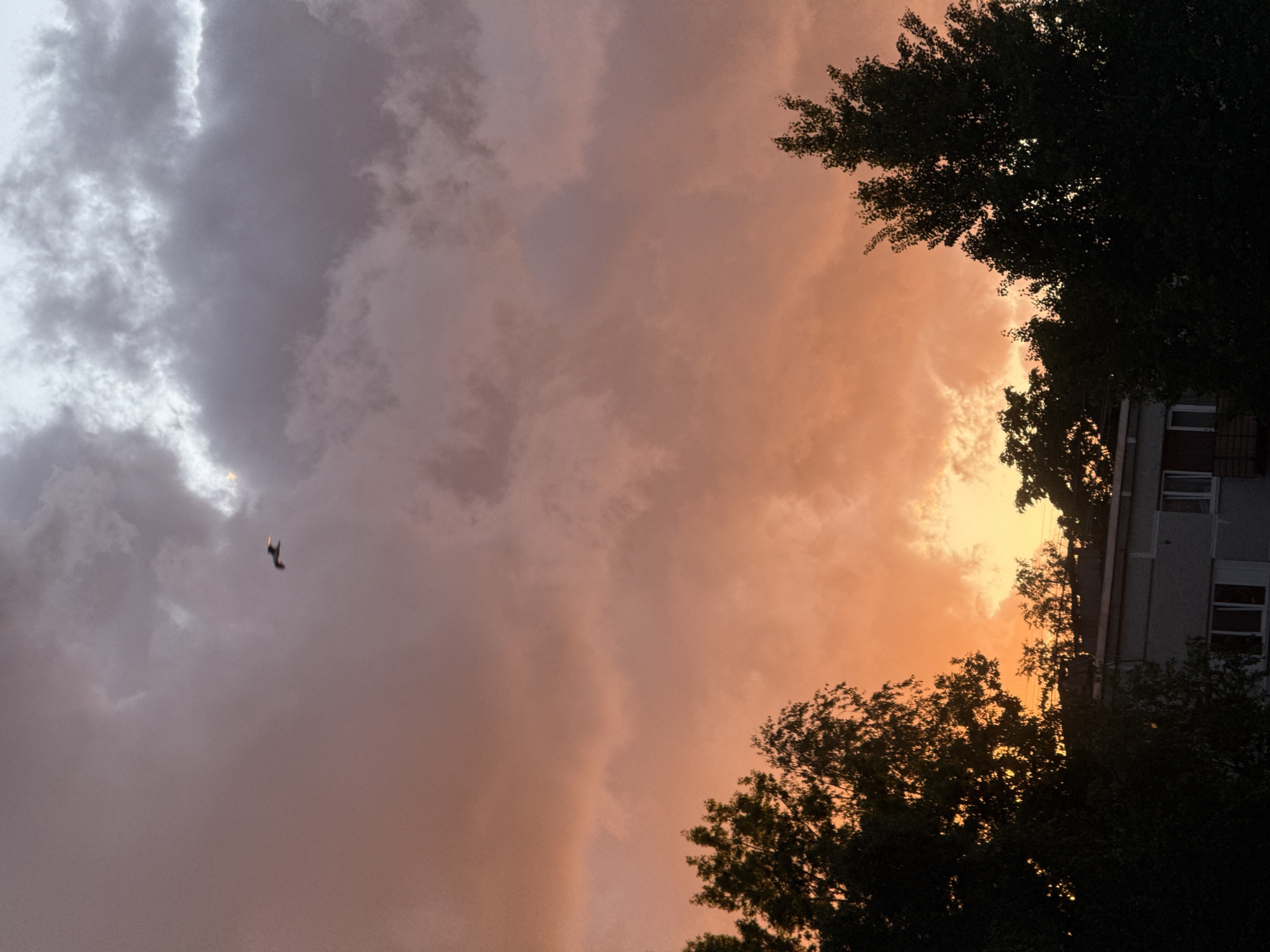 Dramatic storm clouds contrast with sunset over Riga