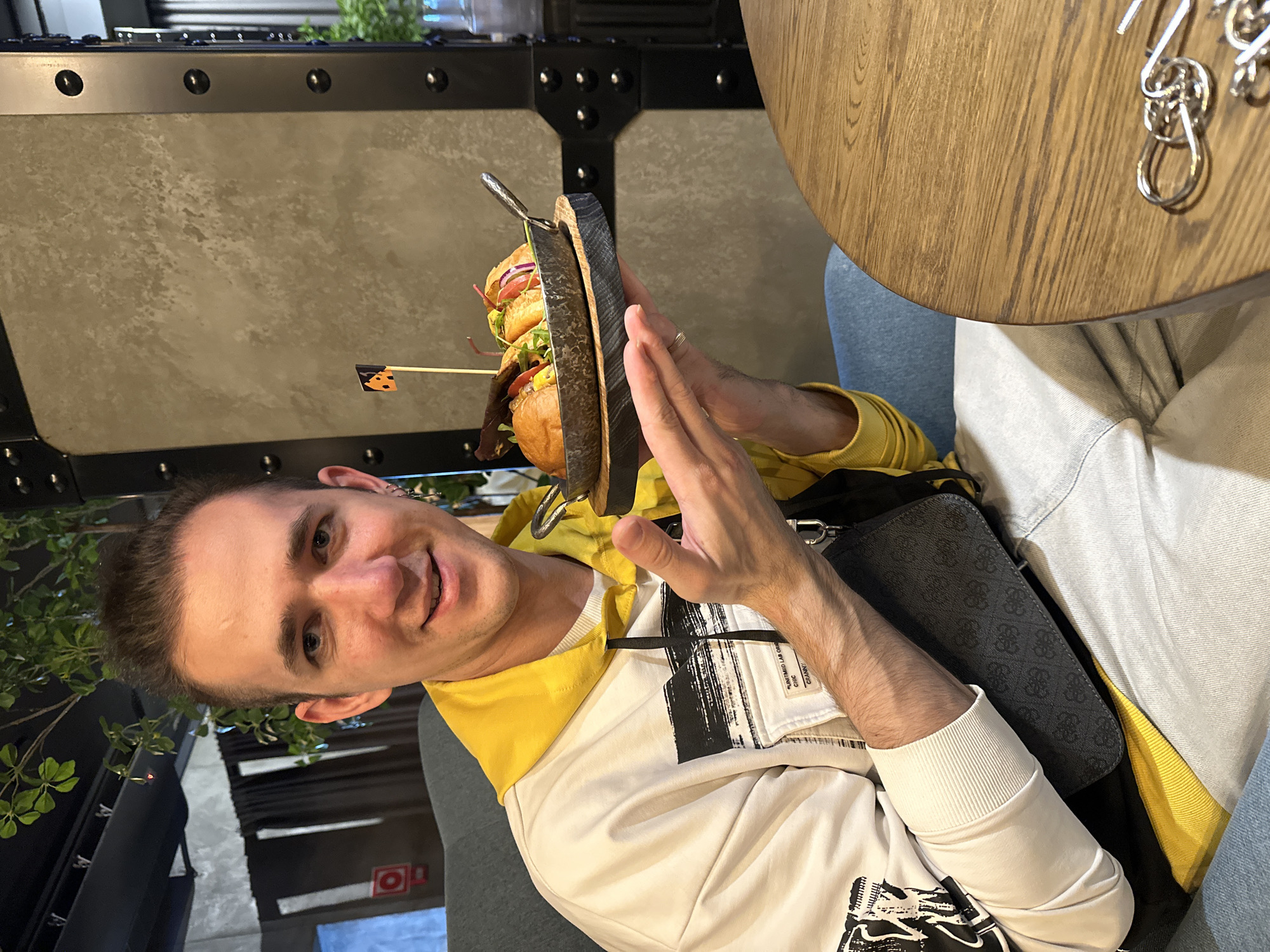 Man holds stacked burger presentation in Saratov restaurant