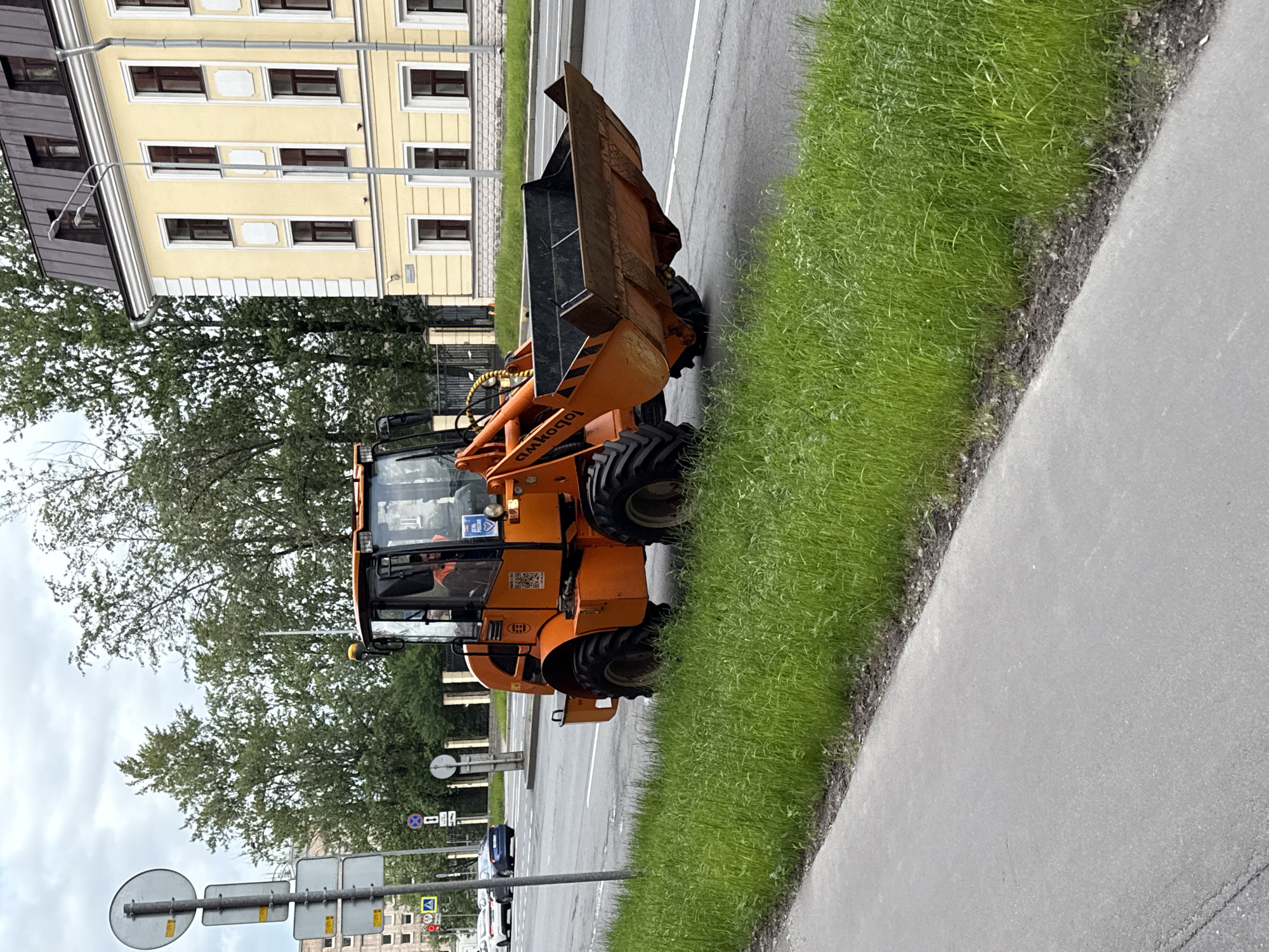 Orange loader parked and moving on a Saint Petersburg street
