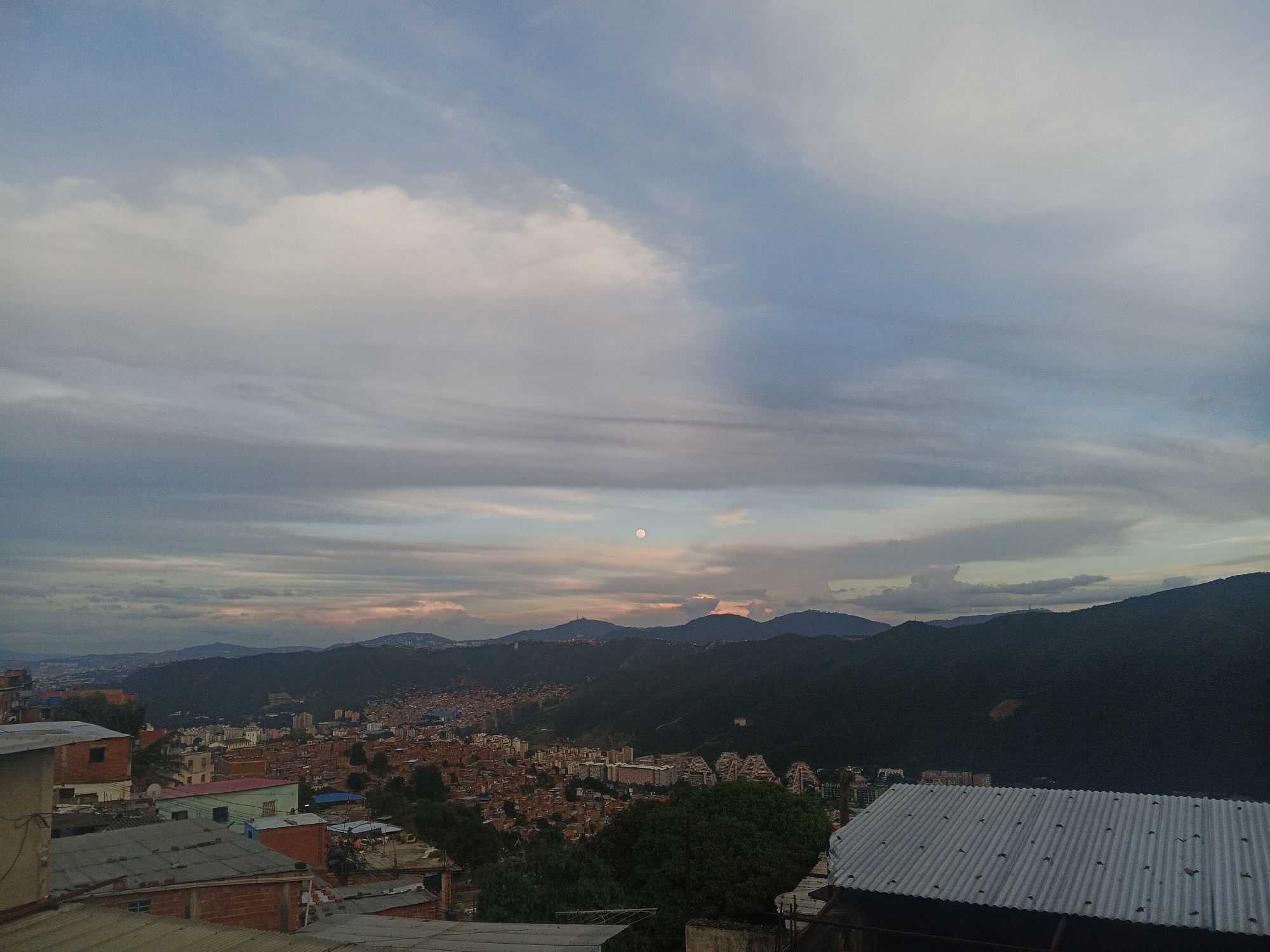 Caracas hillside barrios at dusk, valley and mountains beyond