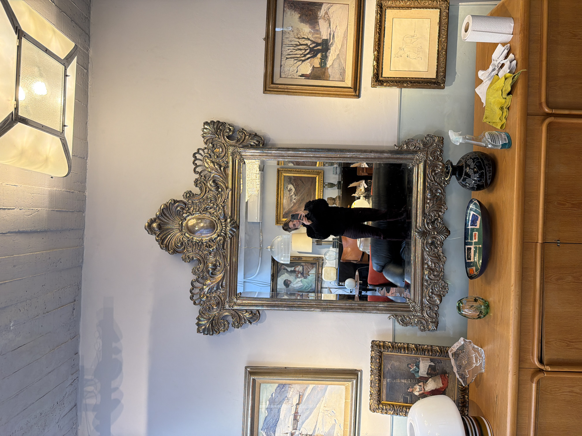 Person takes selfie in ornate mirror at Buenos Aires antique shop