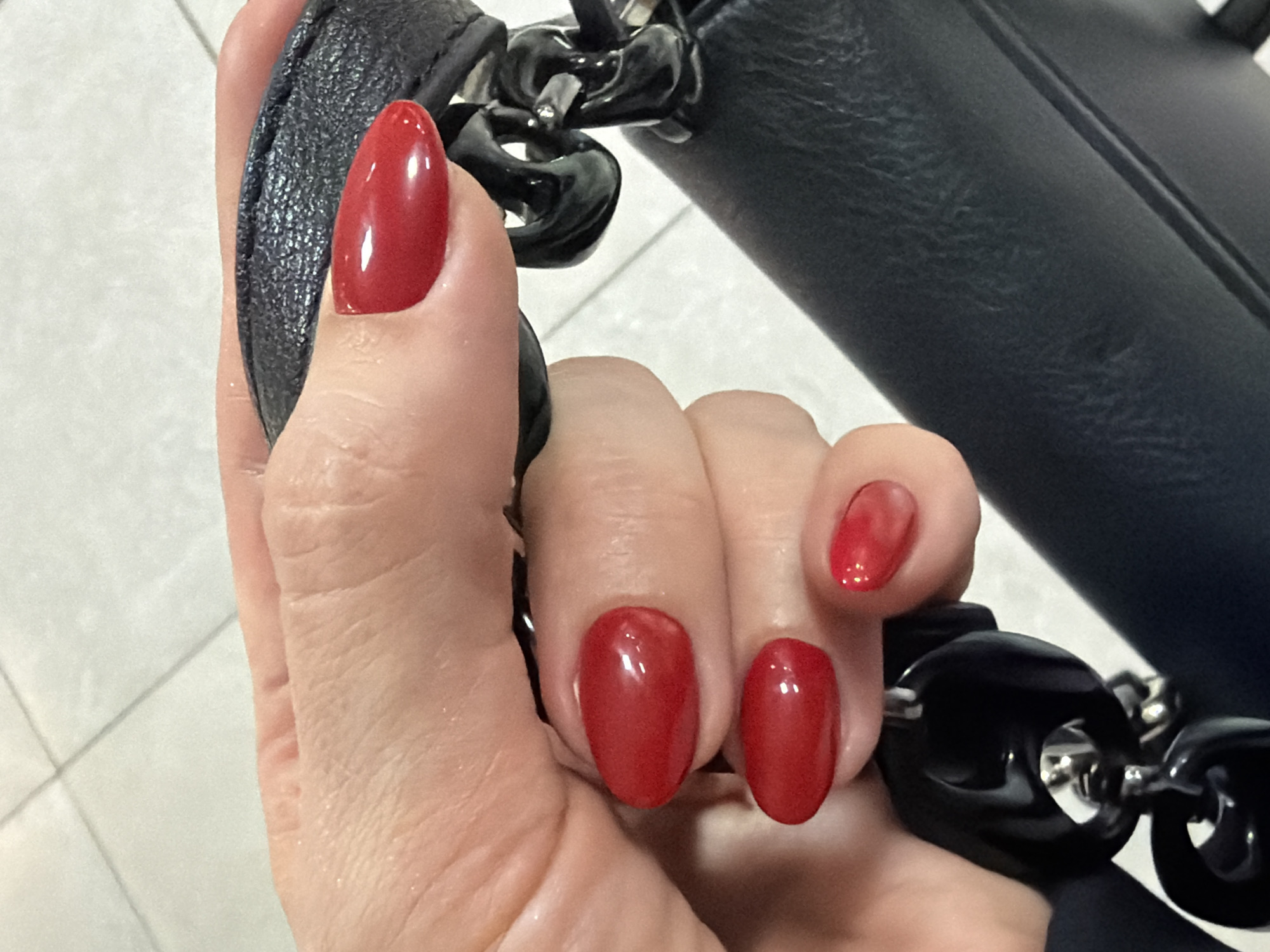 Person with red nails holds decorative leather strap in Ukraine