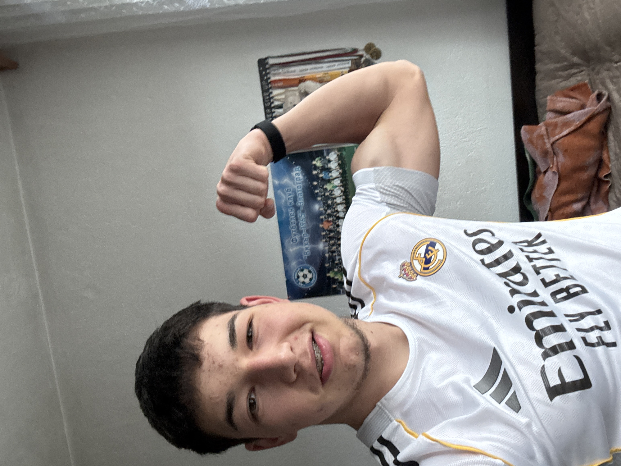 Young man takes selfies flexing in Real Madrid jersey