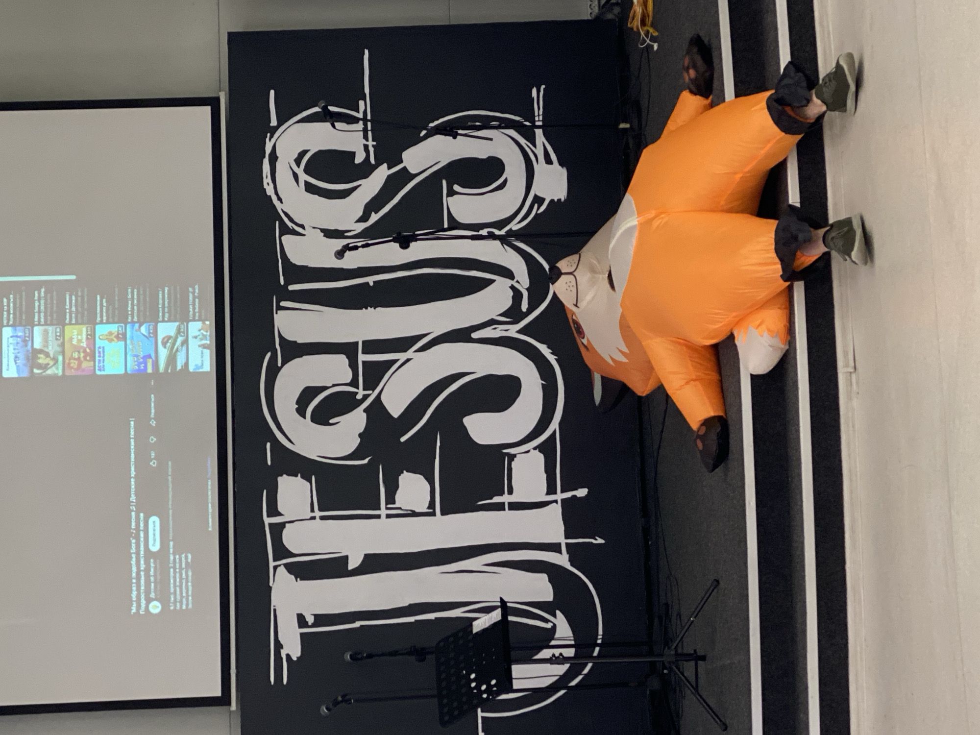 Indoor community event in Chișinău features fox costume, music, and street scenes