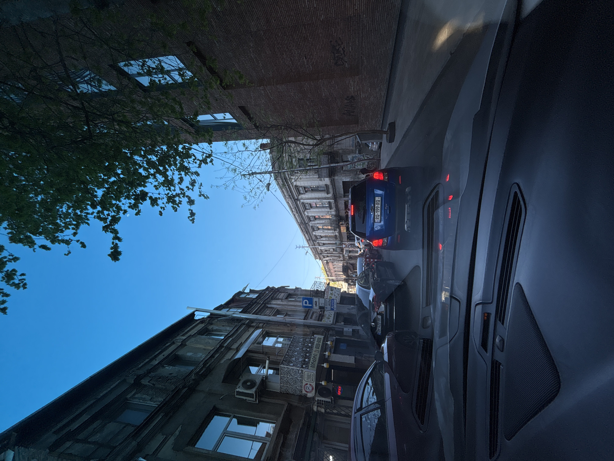 Driver documents mixed architecture during afternoon commute in Tbilisi