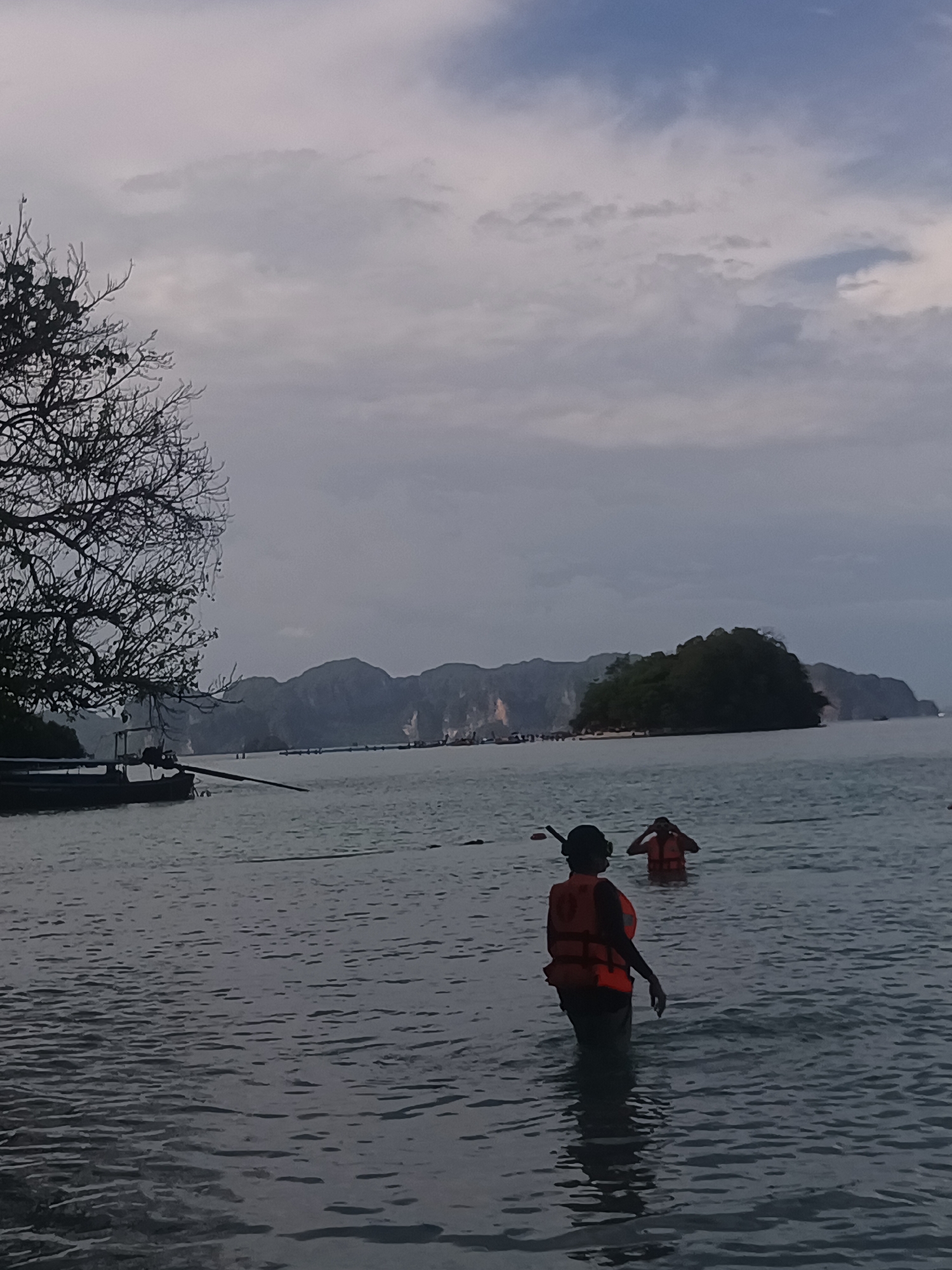 Morning beachgoers navigate murky waters at Ao Nang Thailand