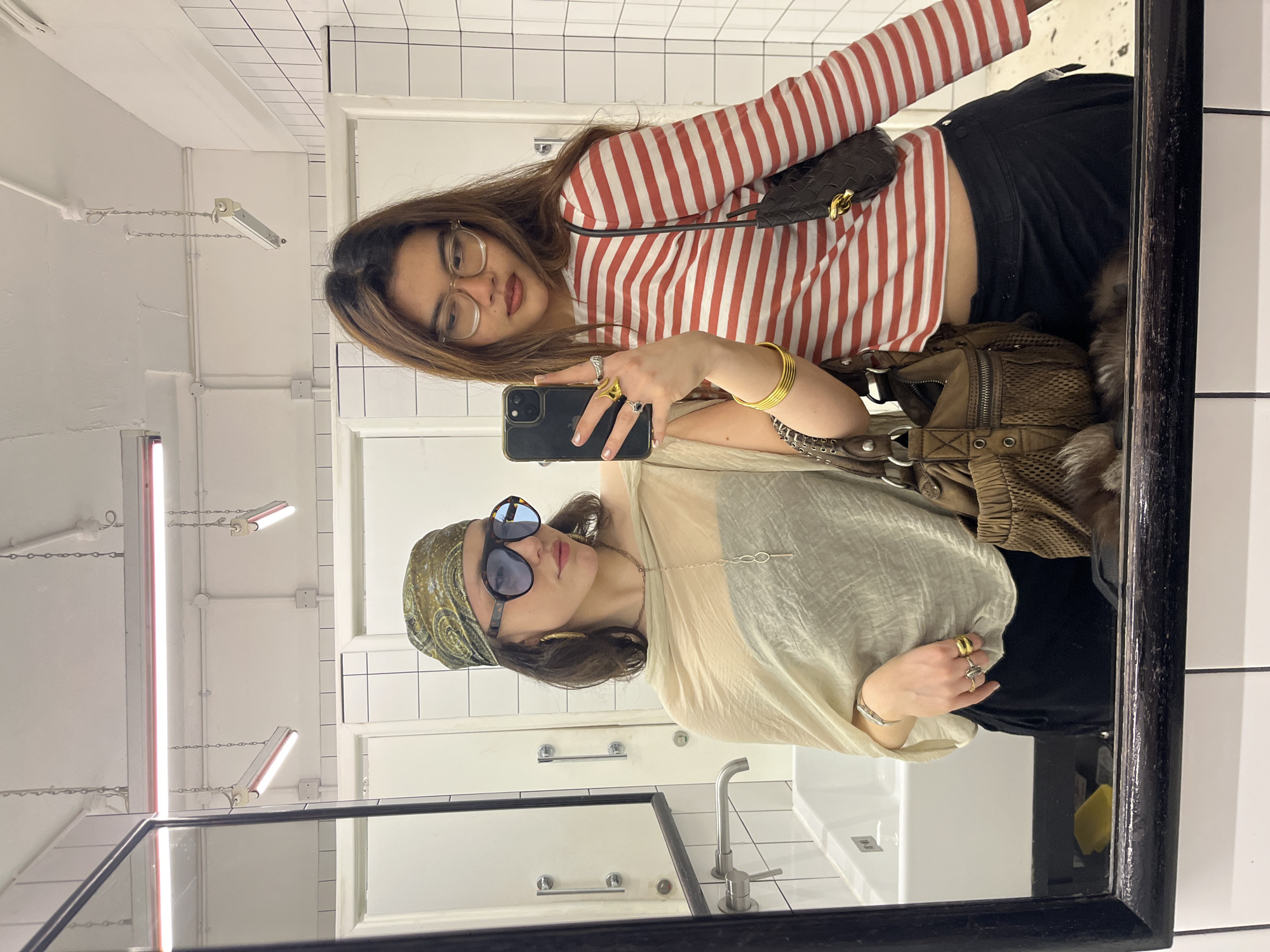 Two women take mirror selfie in London indoor space
