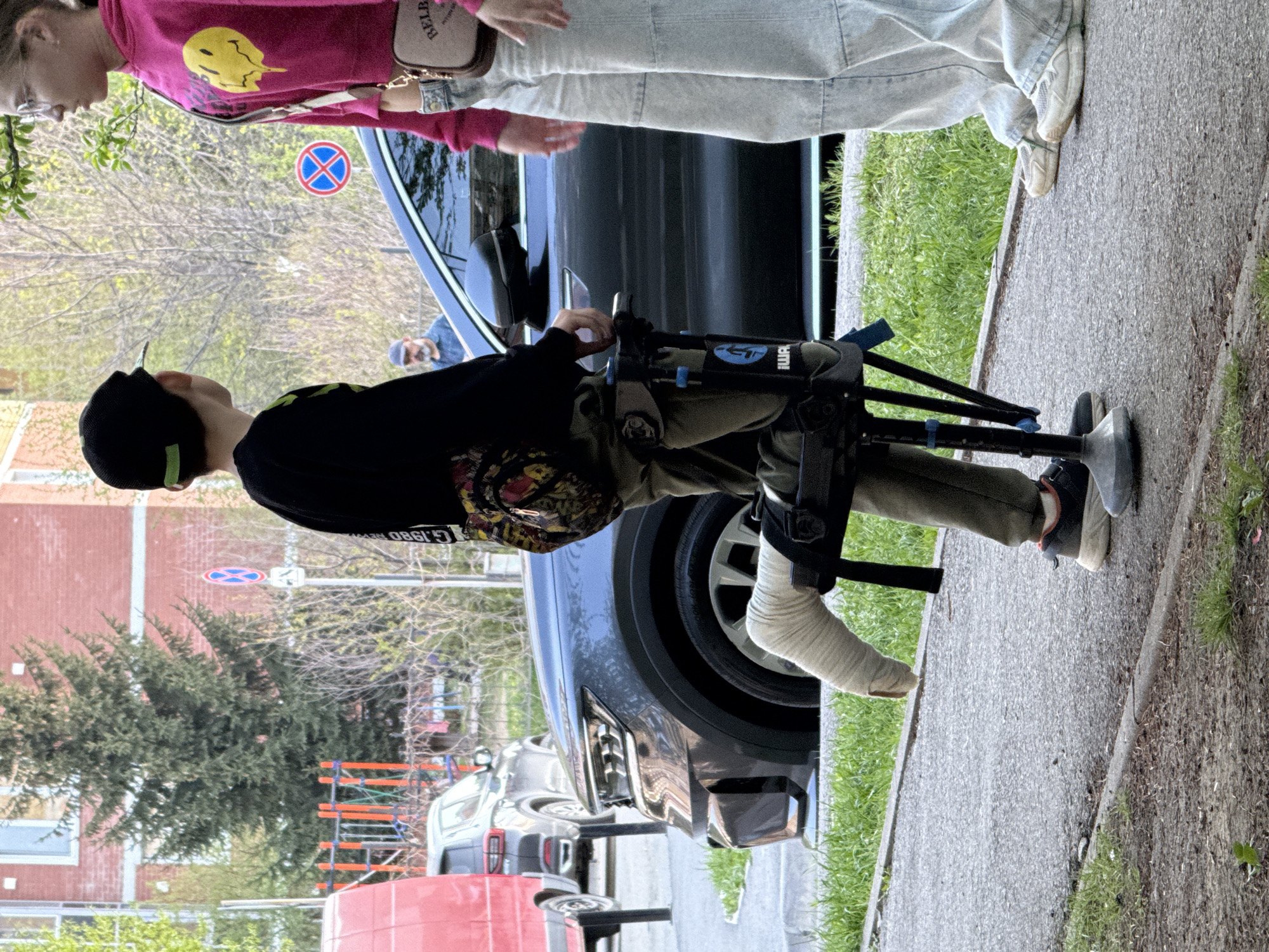 Children play on Yekaterinburg sidewalk, person with cast observed