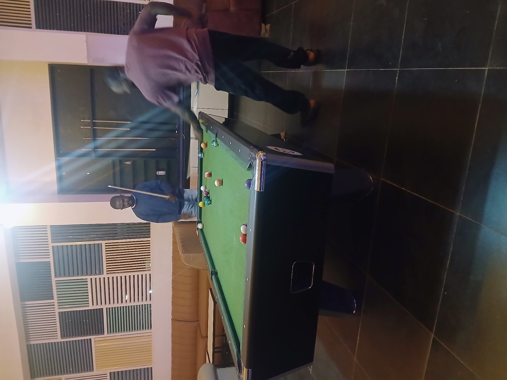 Men play pool at indoor venue in Kitwe