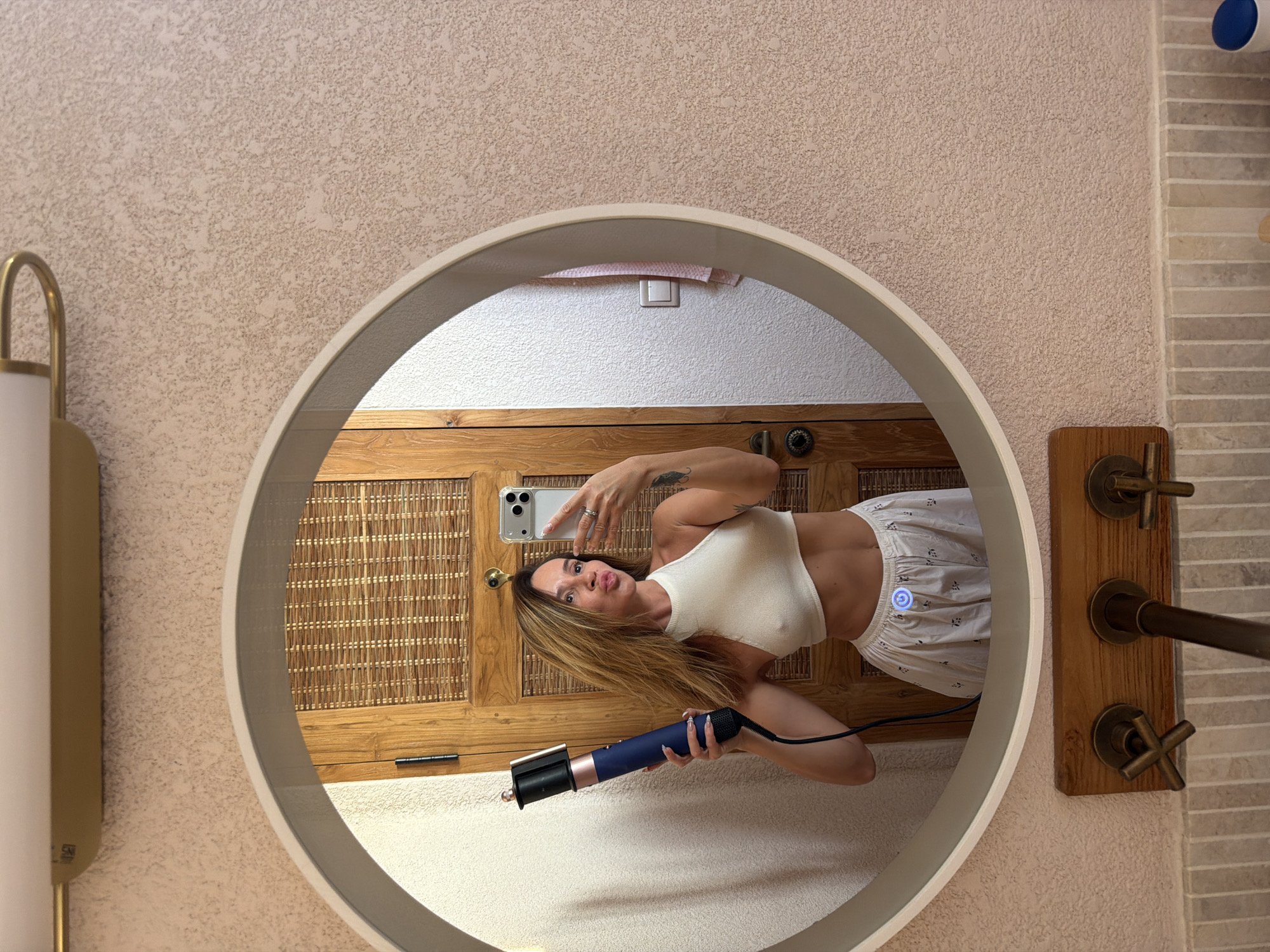 Woman takes bathroom selfie amid skincare products in Mengwi