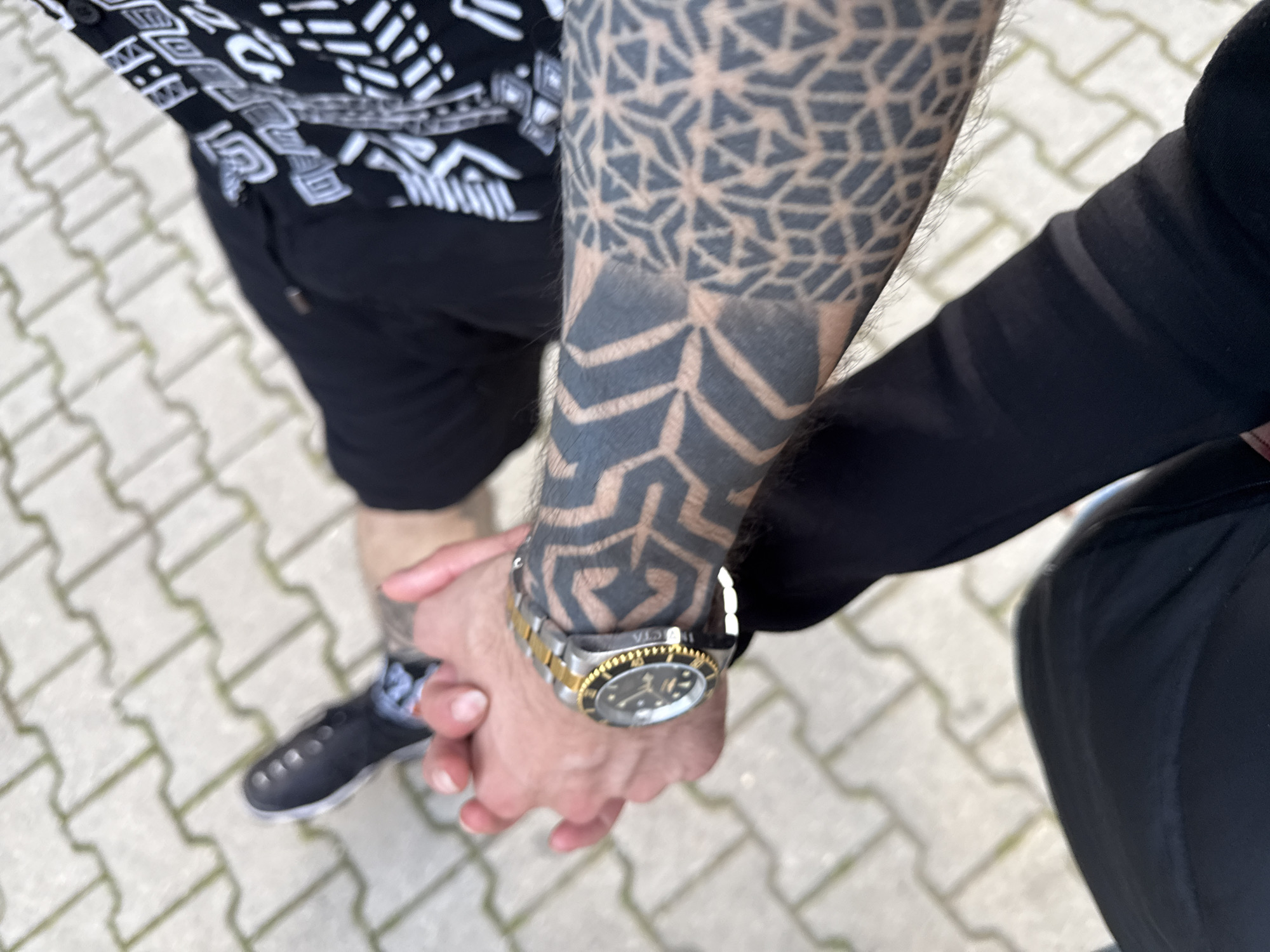 Two people hold hands in outdoor Sofia setting