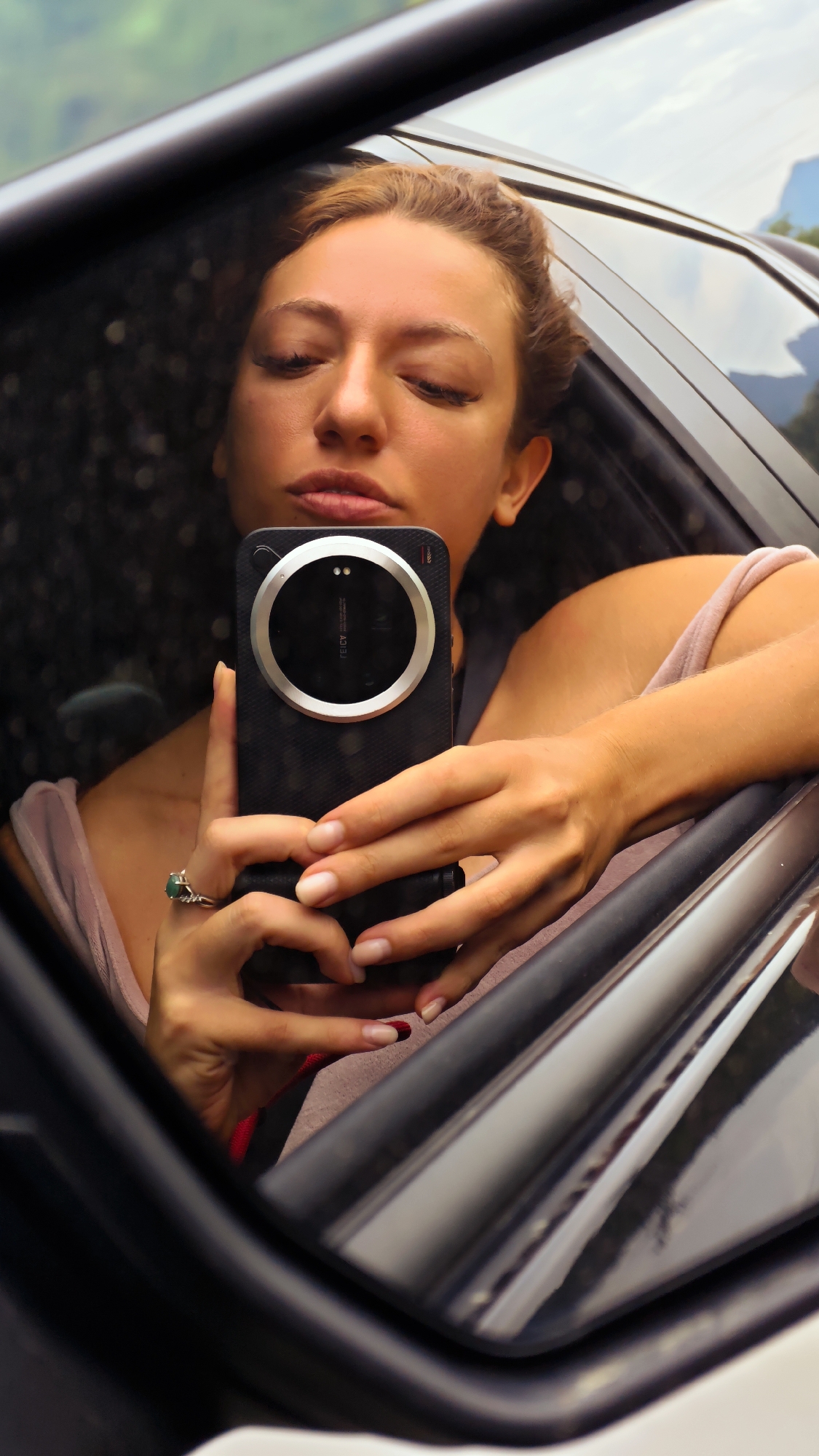Woman takes selfie while traveling rural Vietnam road