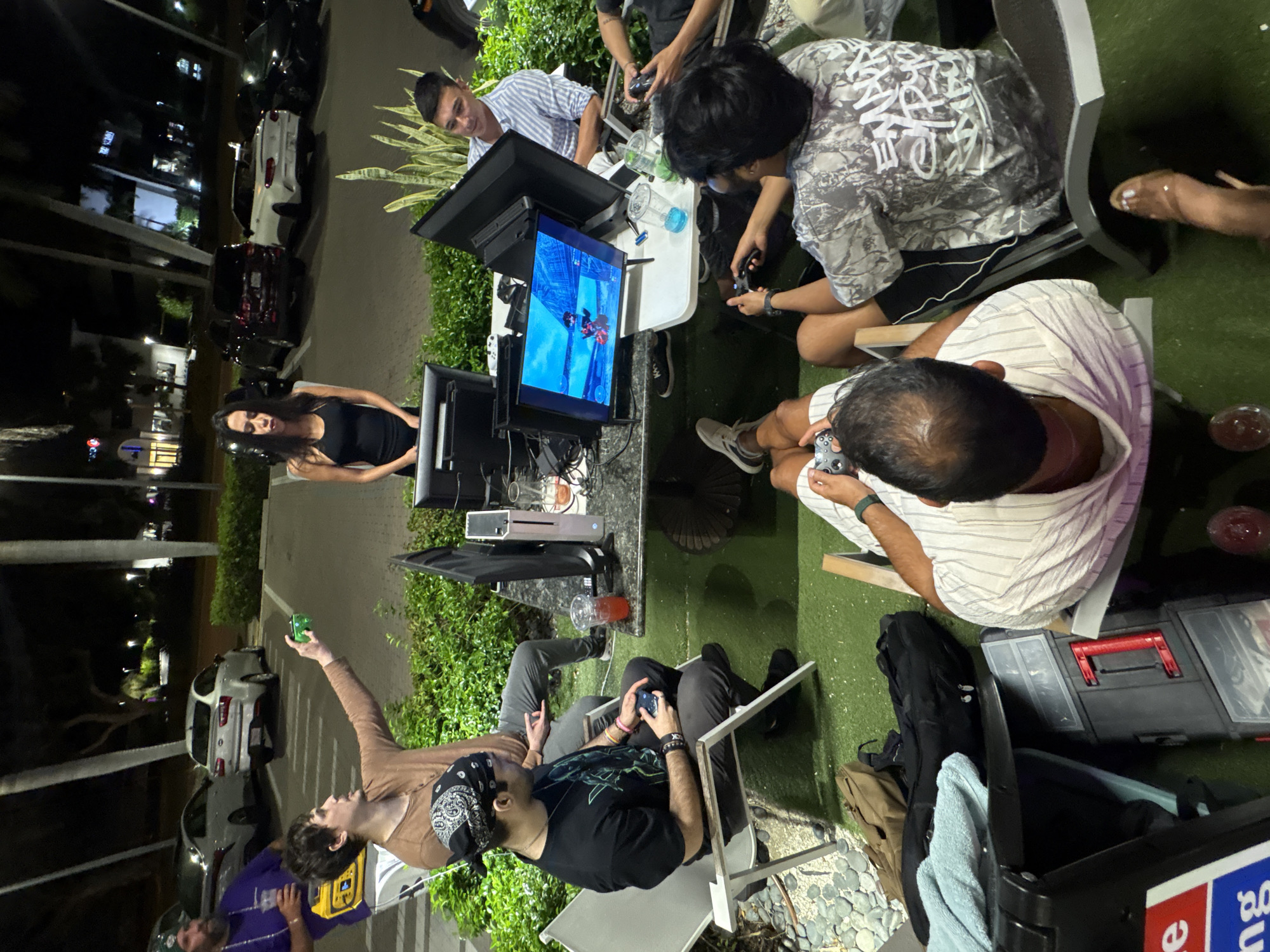 Nighttime outdoor gaming session draws young adults to screens