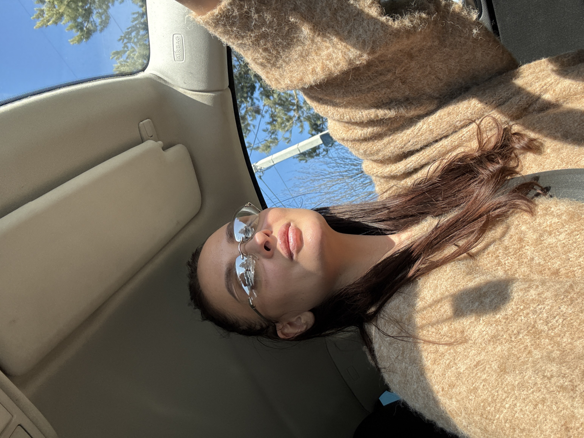 Woman photographed in sunlit car interior in Chaikovsky