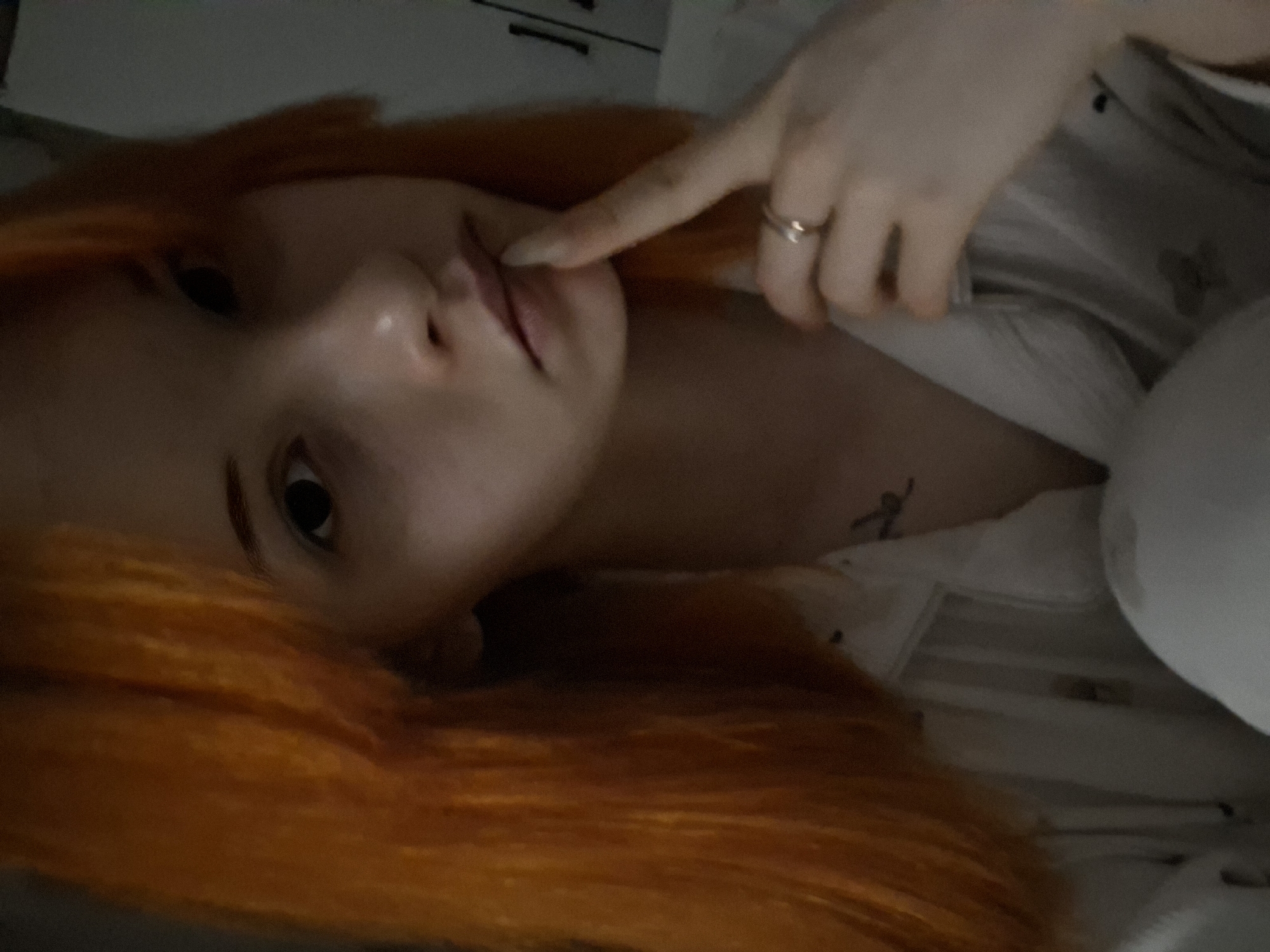 Orange-haired person photographed in low-light conditions