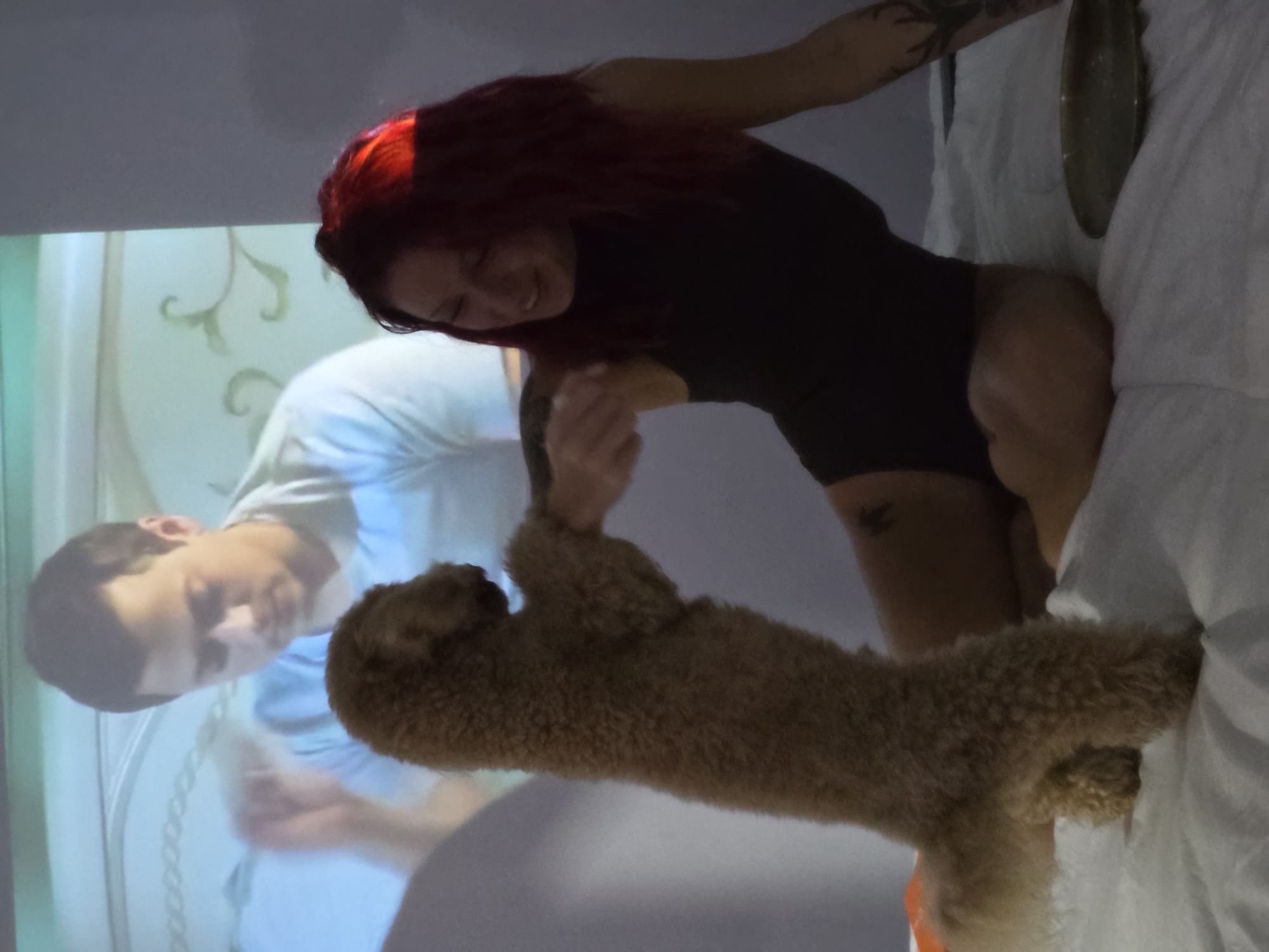 Woman plays with dog in bedroom in Mengwi, Indonesia