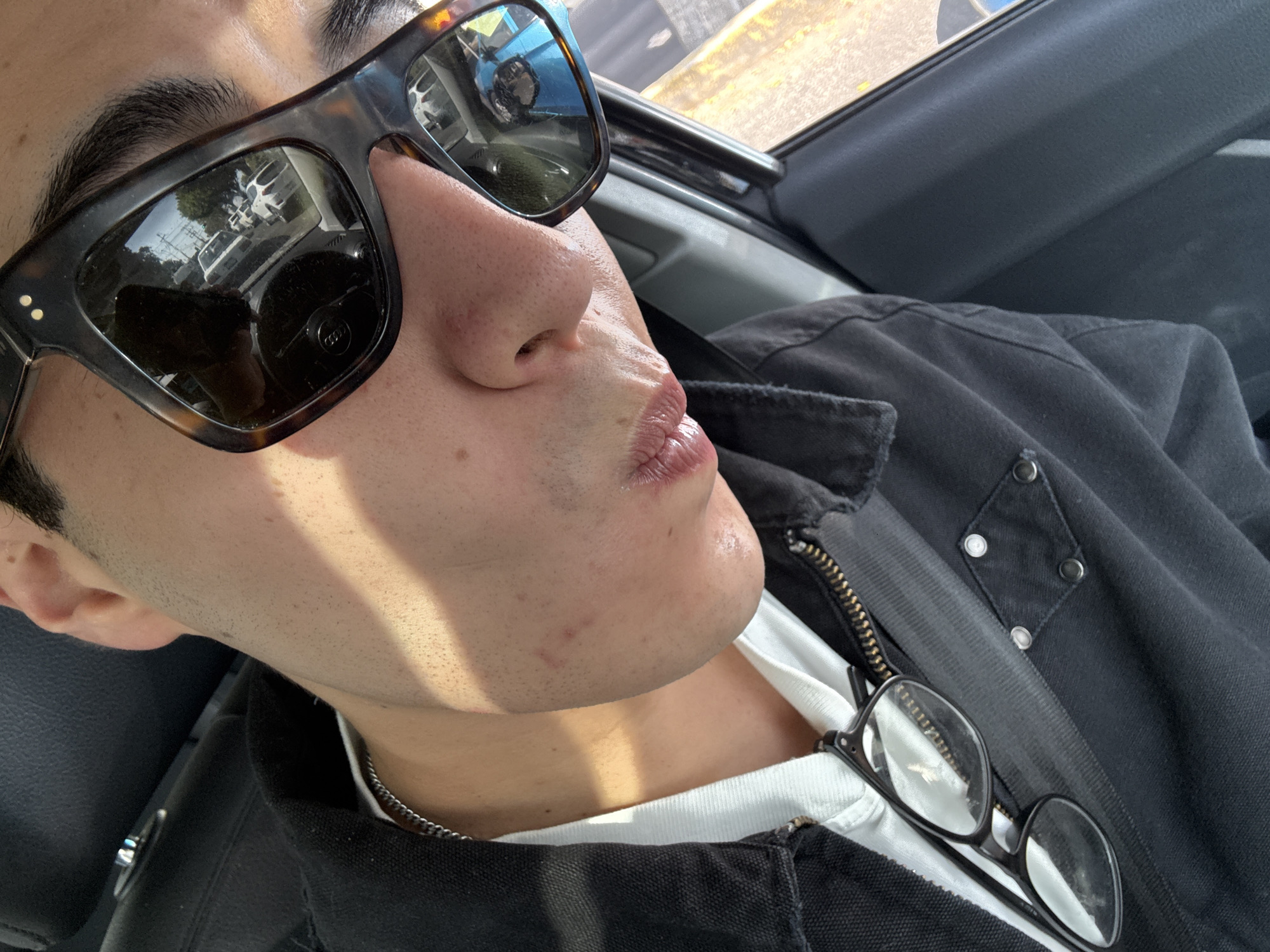 Person in tortoiseshell sunglasses photographed inside vehicle in Puebla