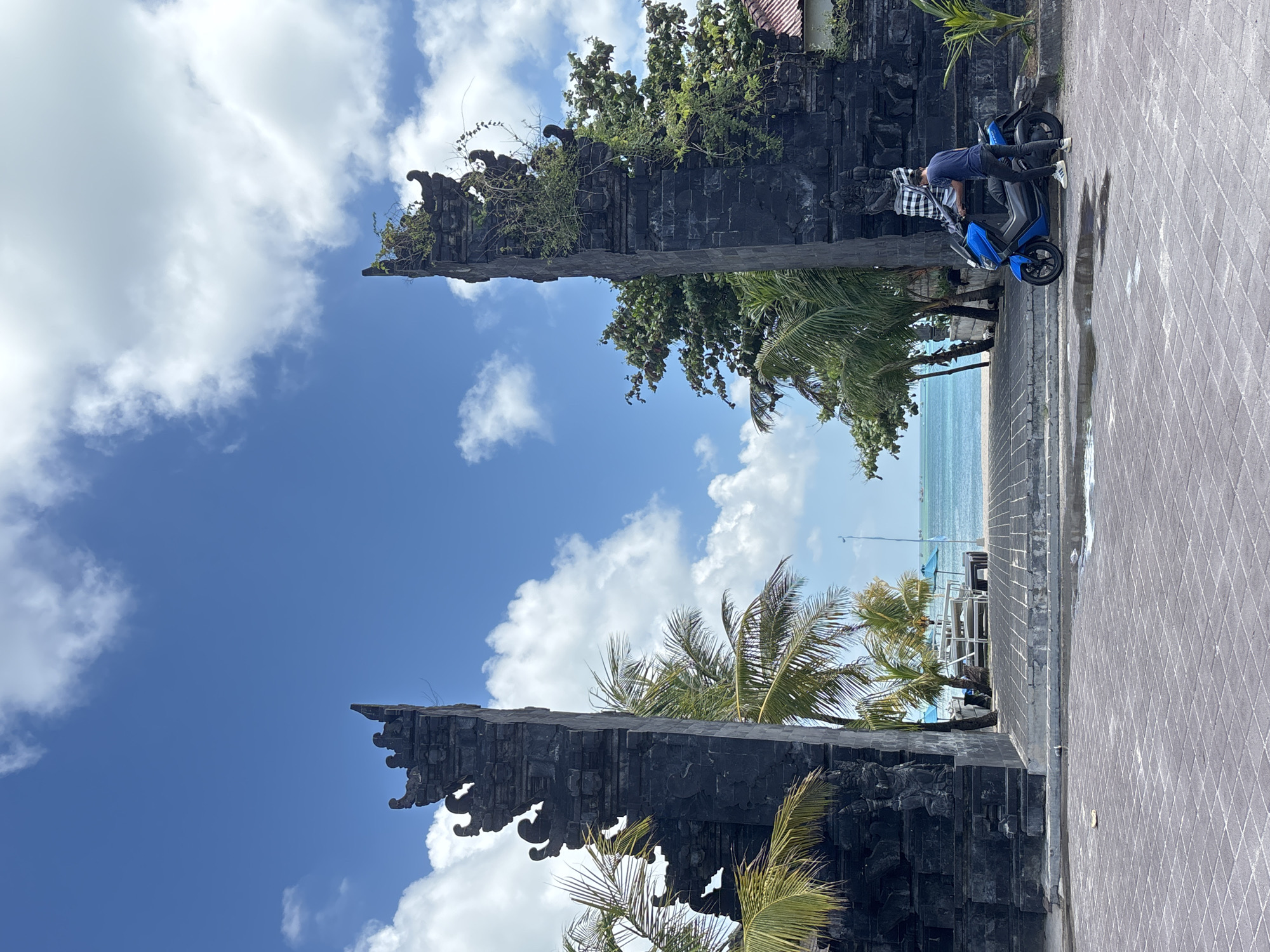 Tourist photographs iconic Kuta gate under morning sky