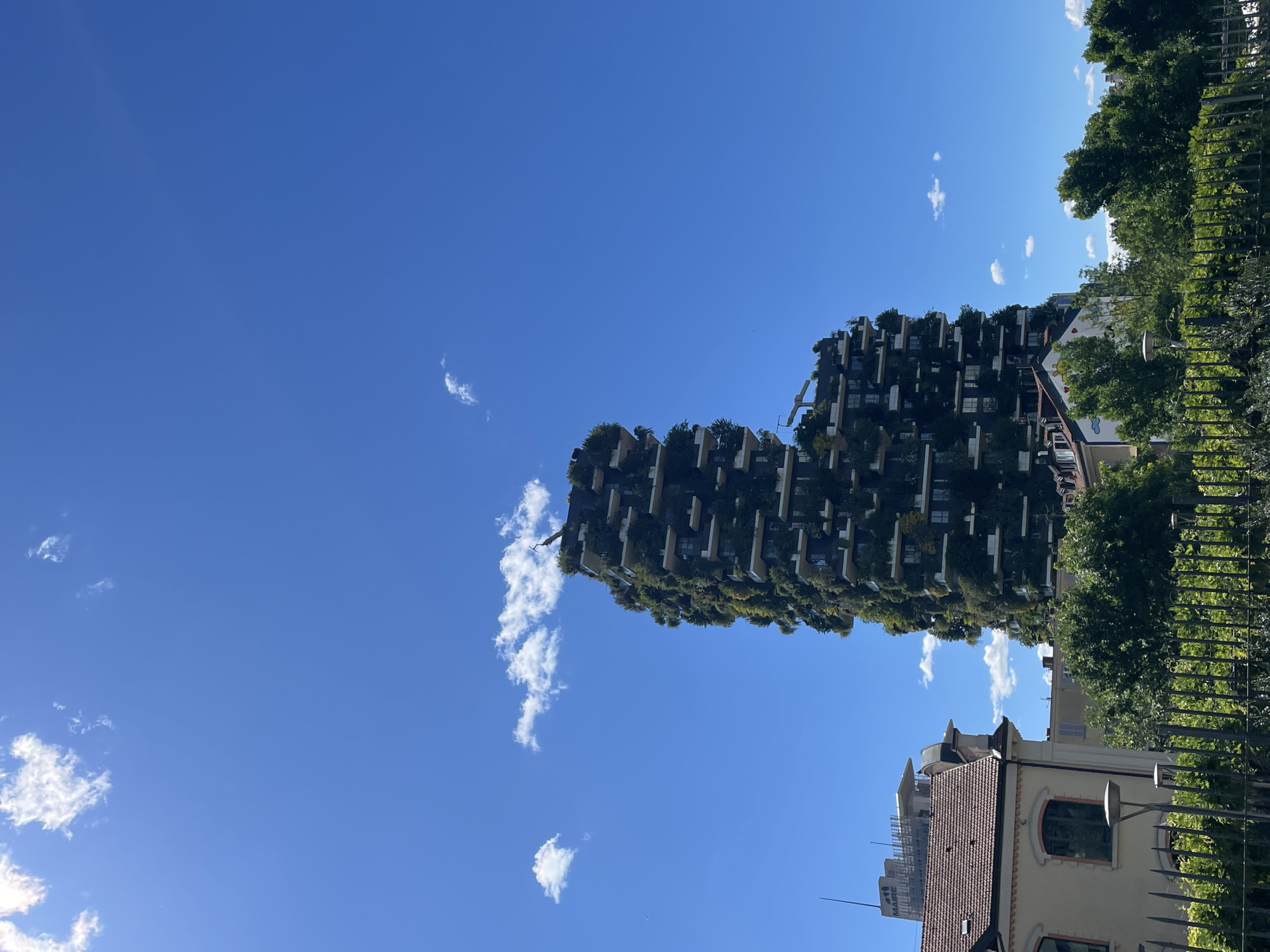 Milan's Vertical Forest towers documented under clear skies