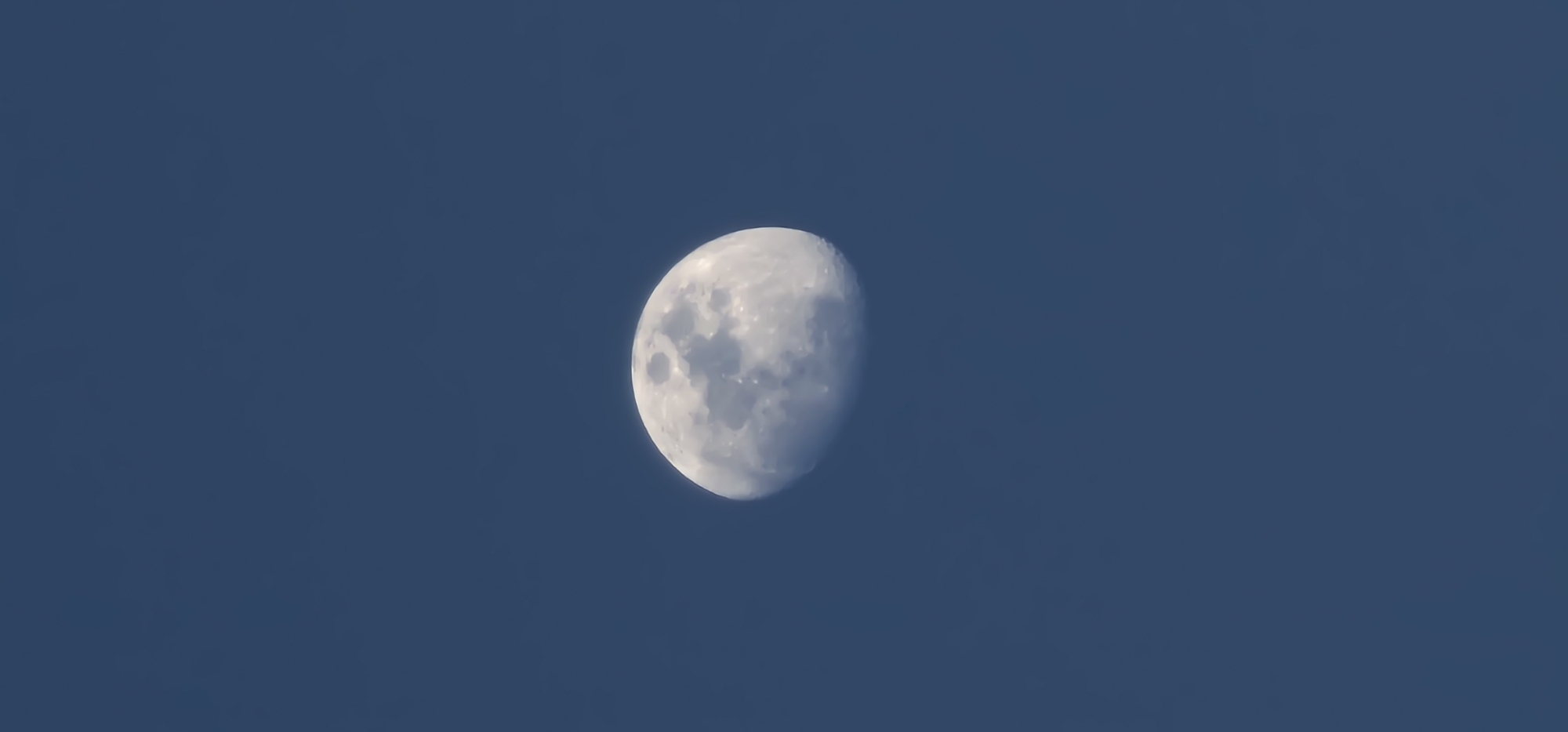Moon, architecture, and poolside light in afternoon Doha