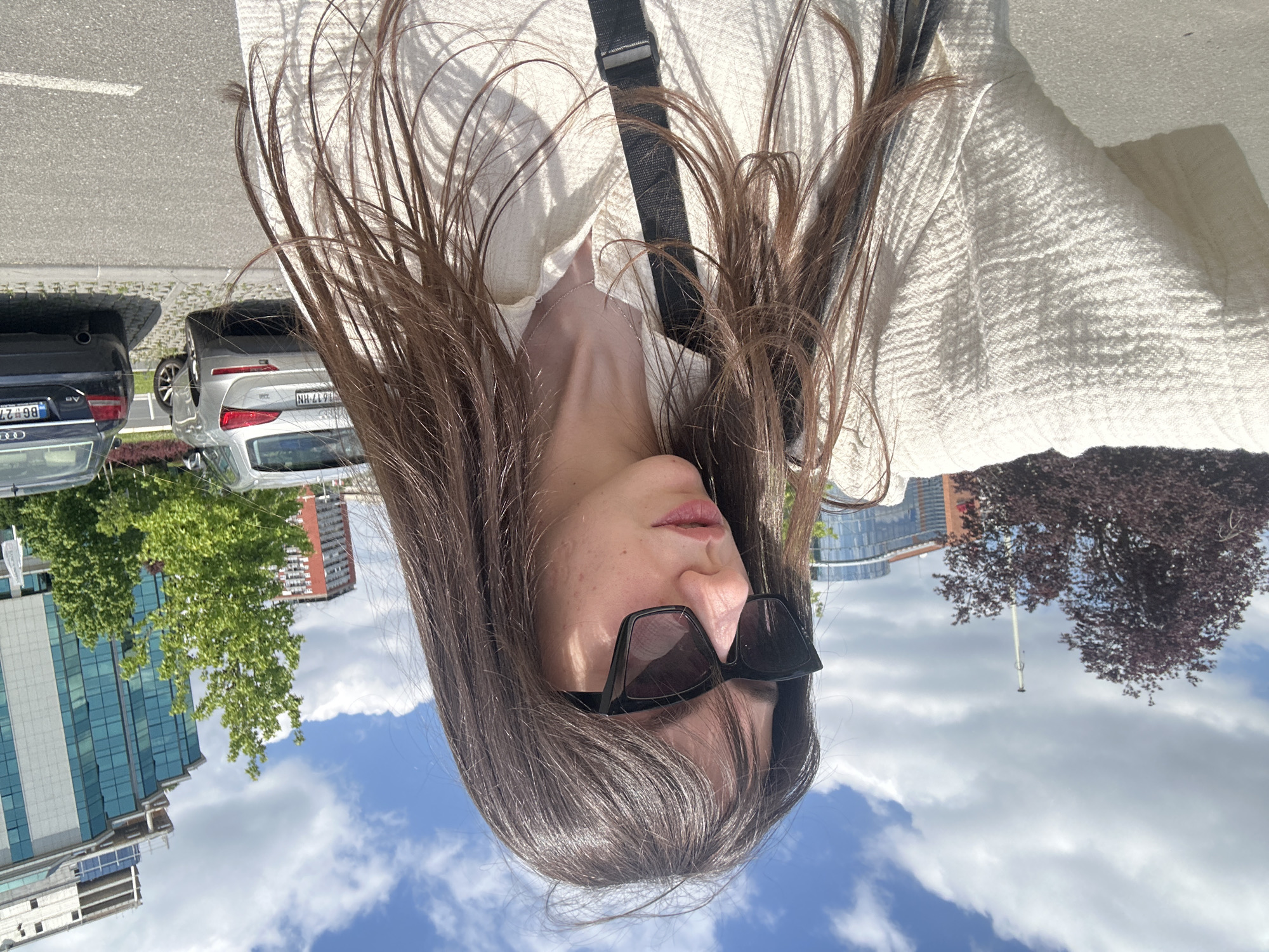 Woman photographed on Belgrade street amid parked cars
