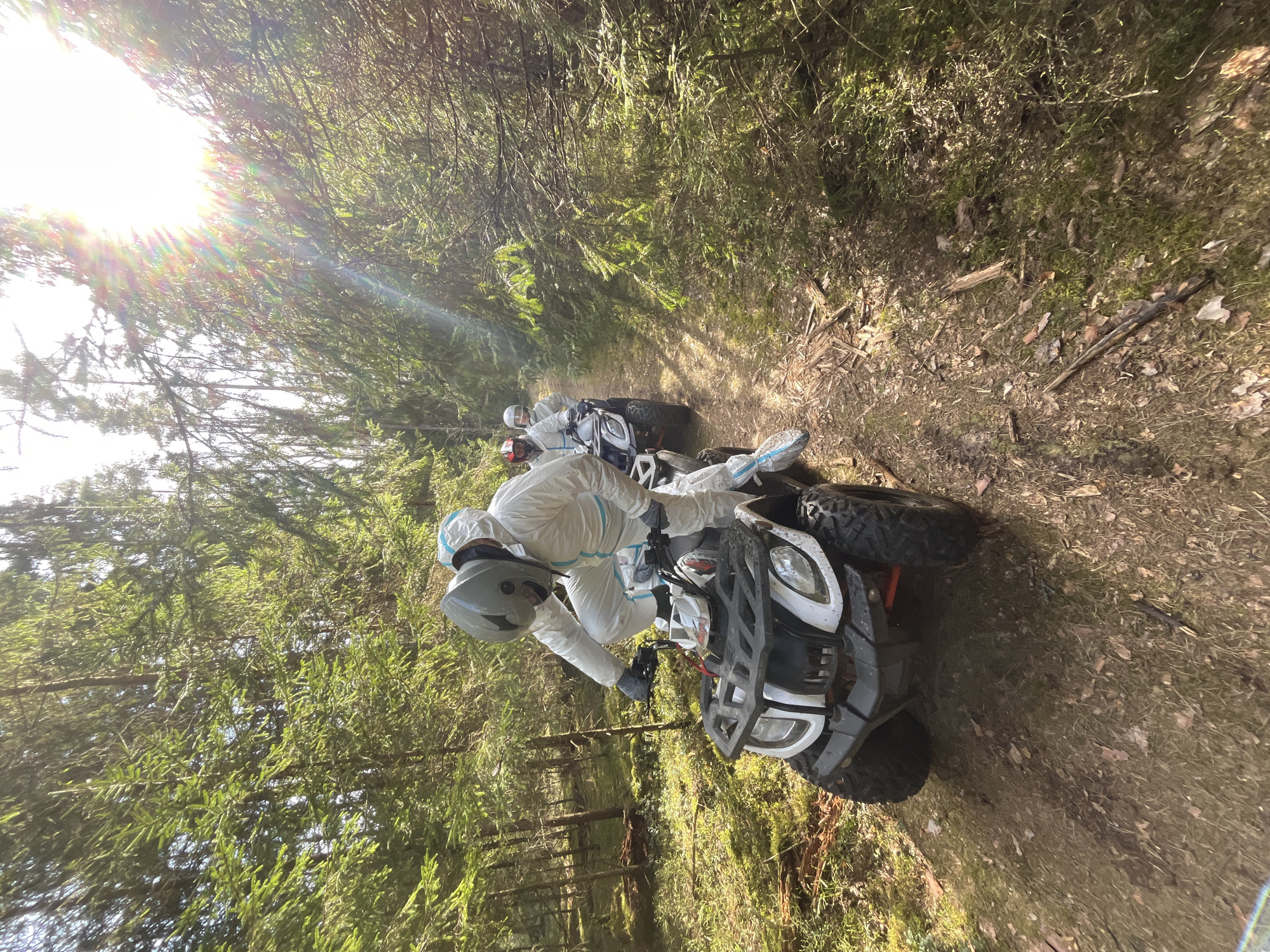 Protected riders operate ATVs with equipment in Russian forest