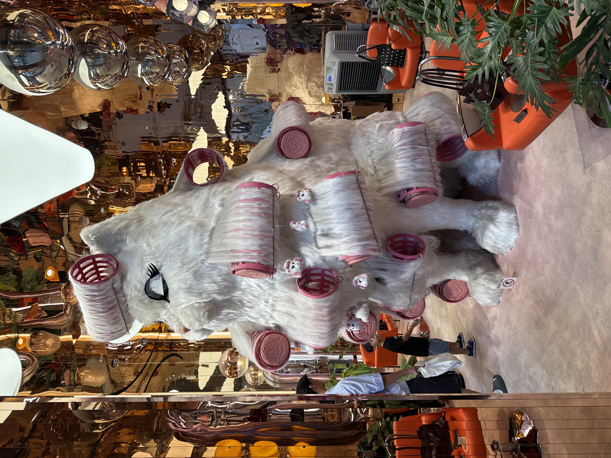 Oversized white cat sculpture with pink rollers in Bangkok retail display