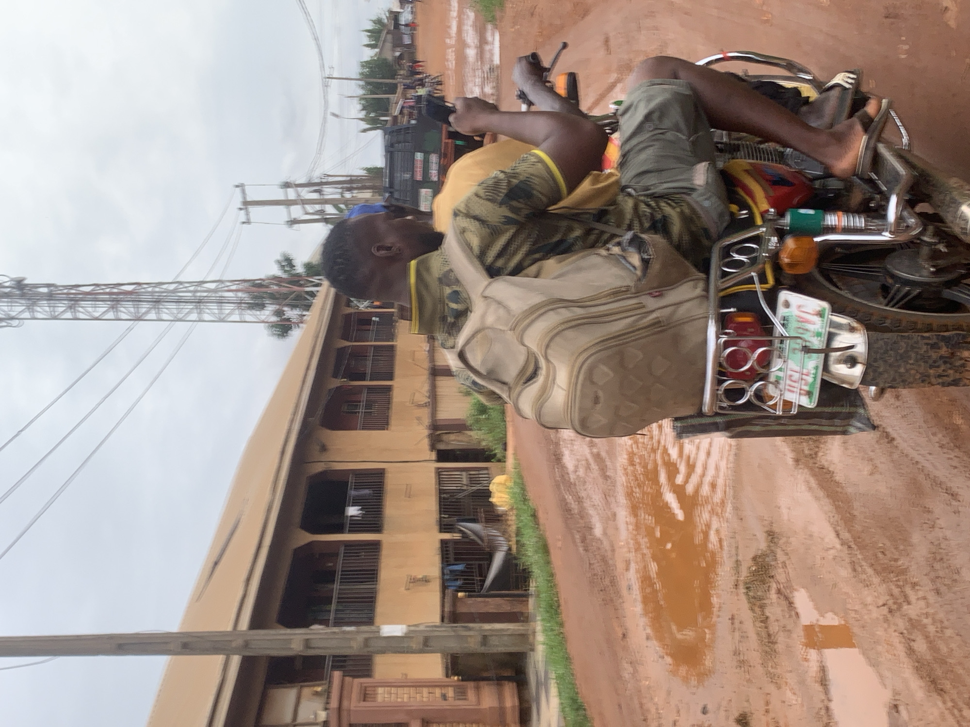 Motorcycle navigates flooded road in Nsugpe, Nigeria
