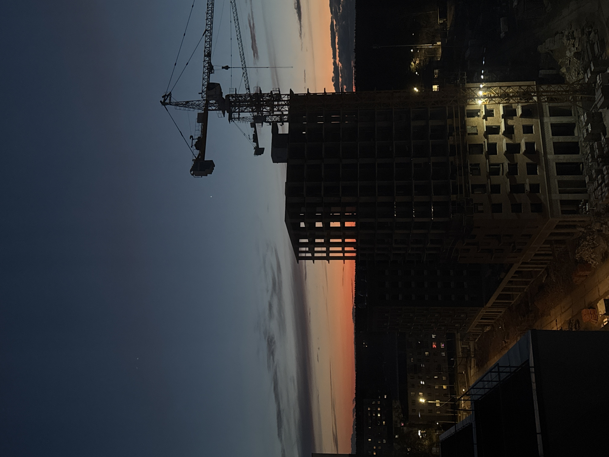 Tower cranes silhouetted at Izhevsk construction site during sunset