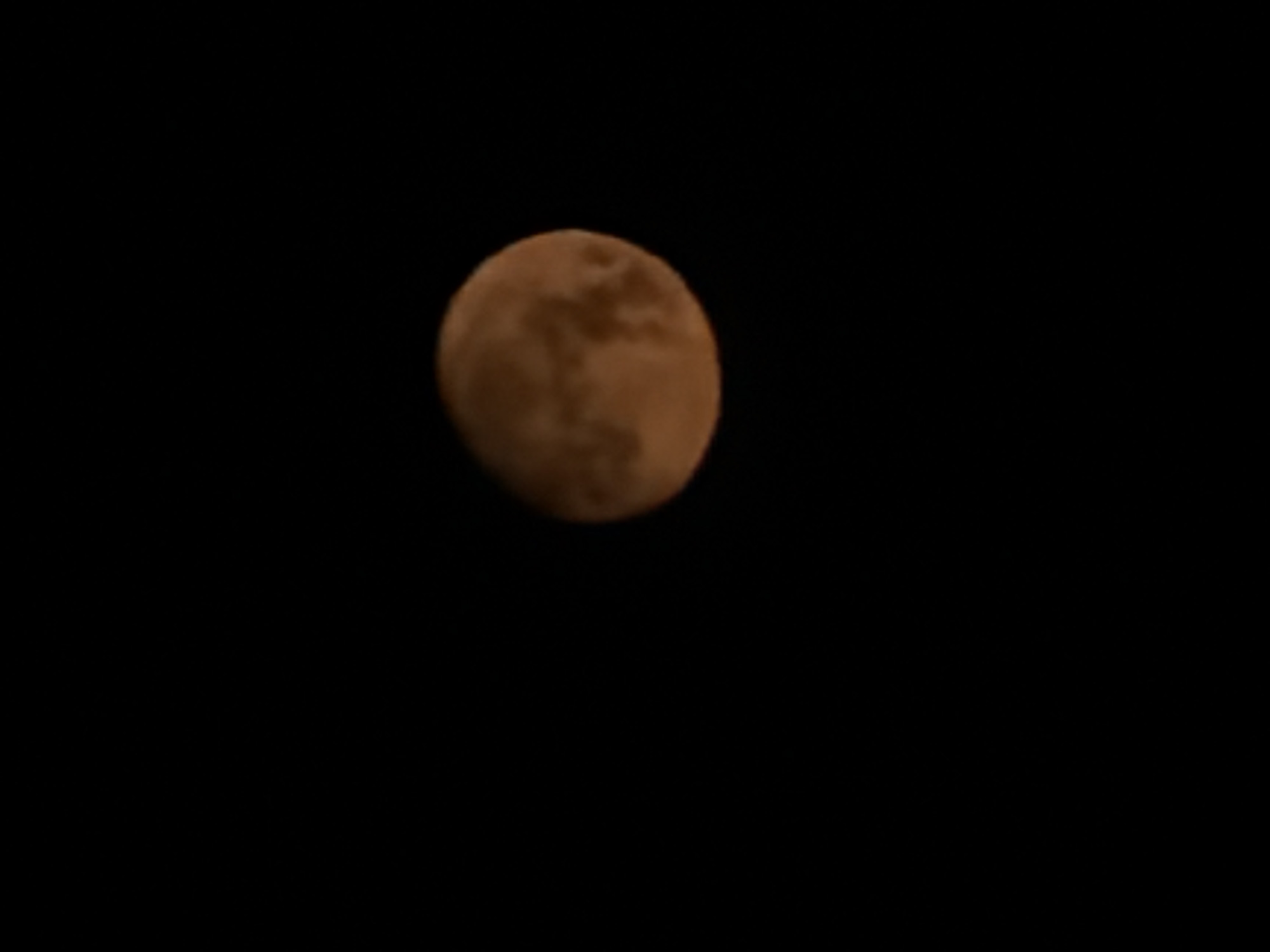 Reddish moon photographed over Wrocław on a summer night