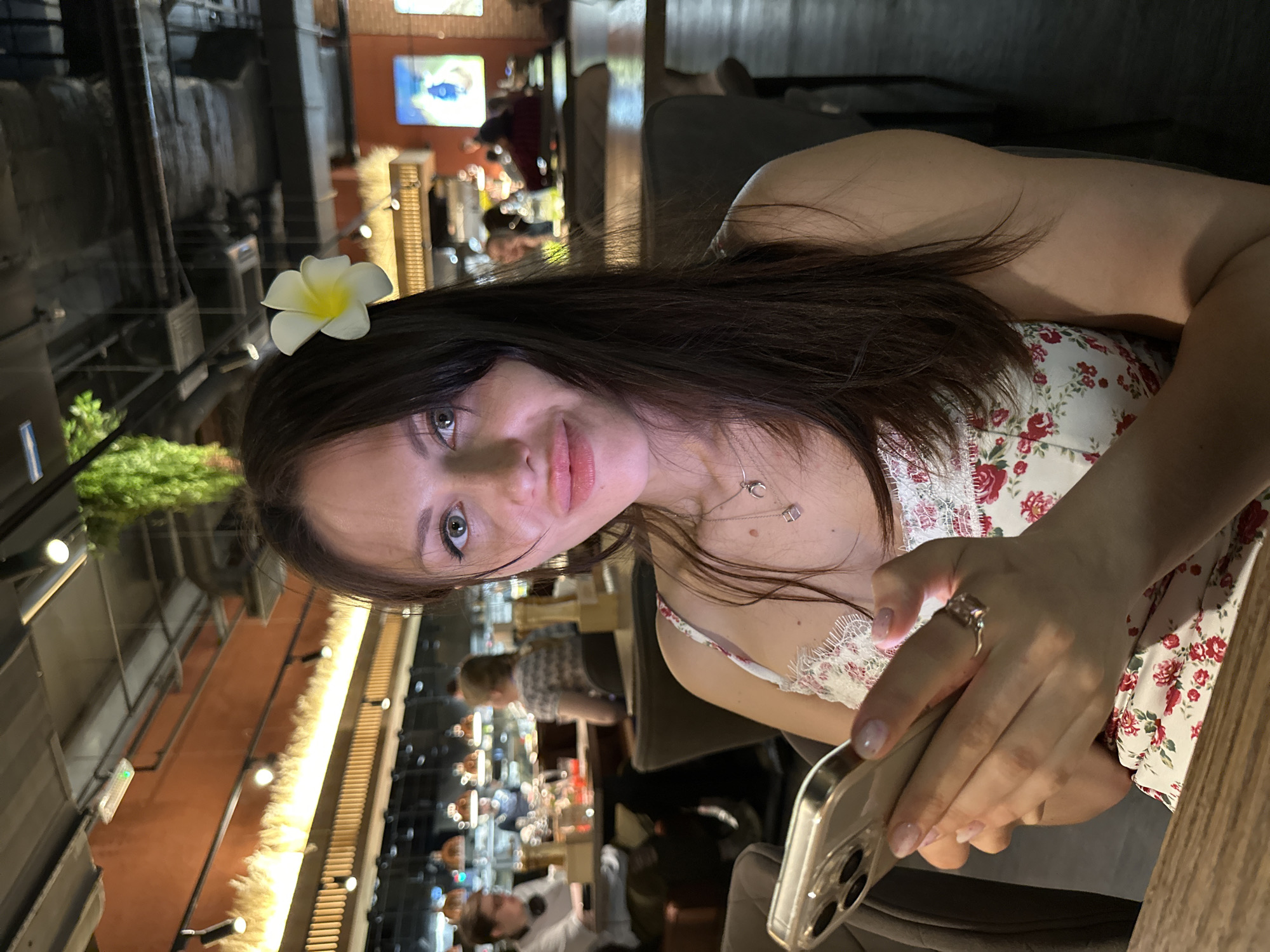 Woman with flower uses phone at Saint Petersburg restaurant