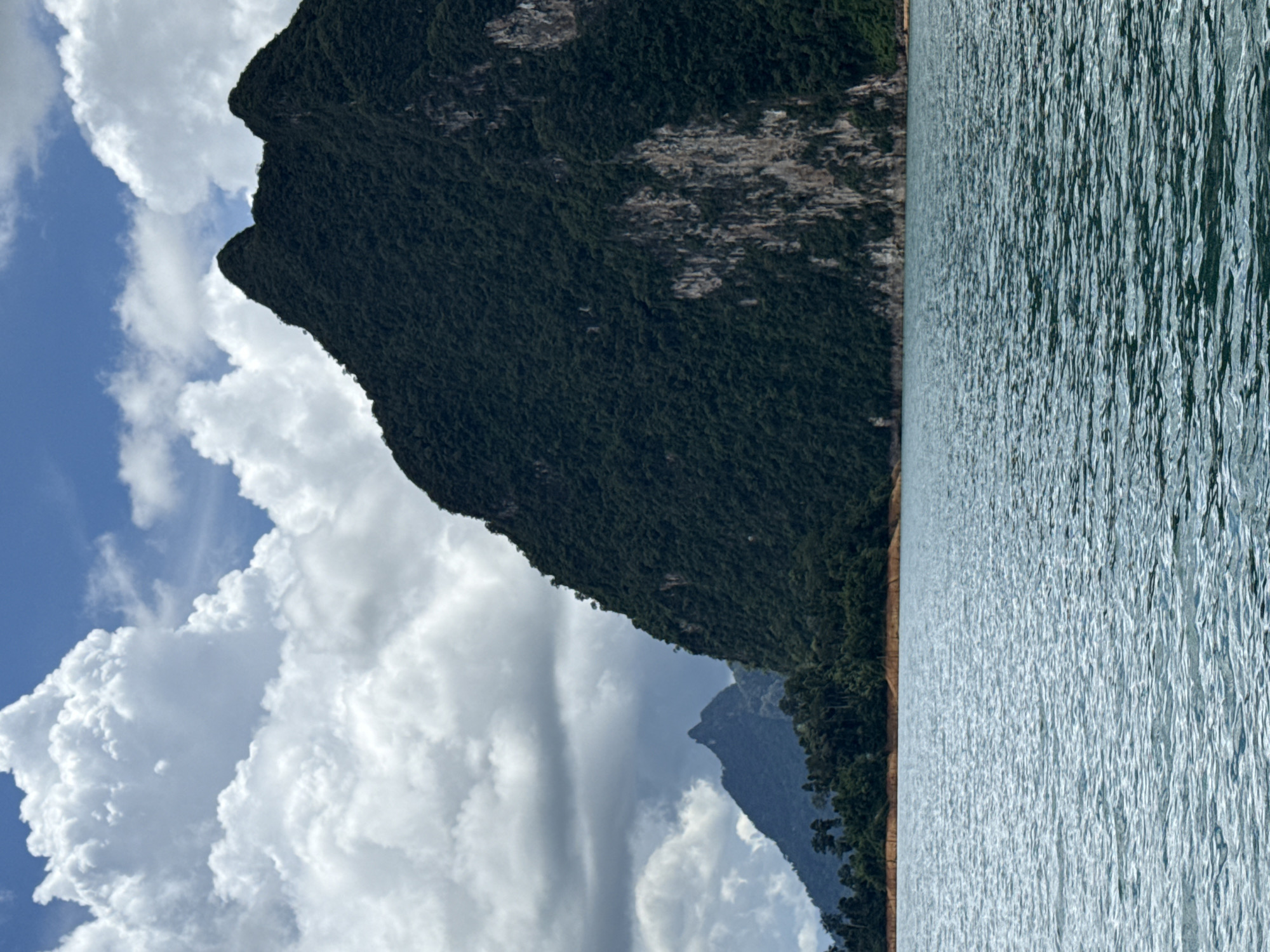 Limestone karsts rise from calm water at Khao Phang