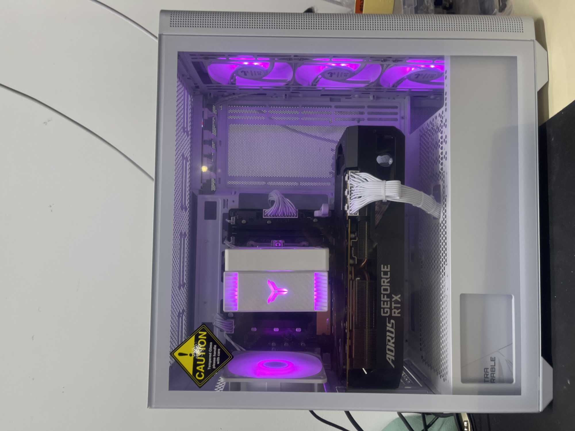 Open white PC case showing RTX GPU and purple LED internals