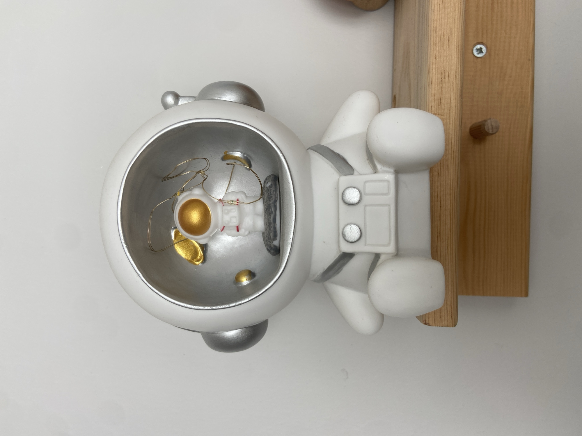 Astronaut figurine with wire lights on a wooden shelf