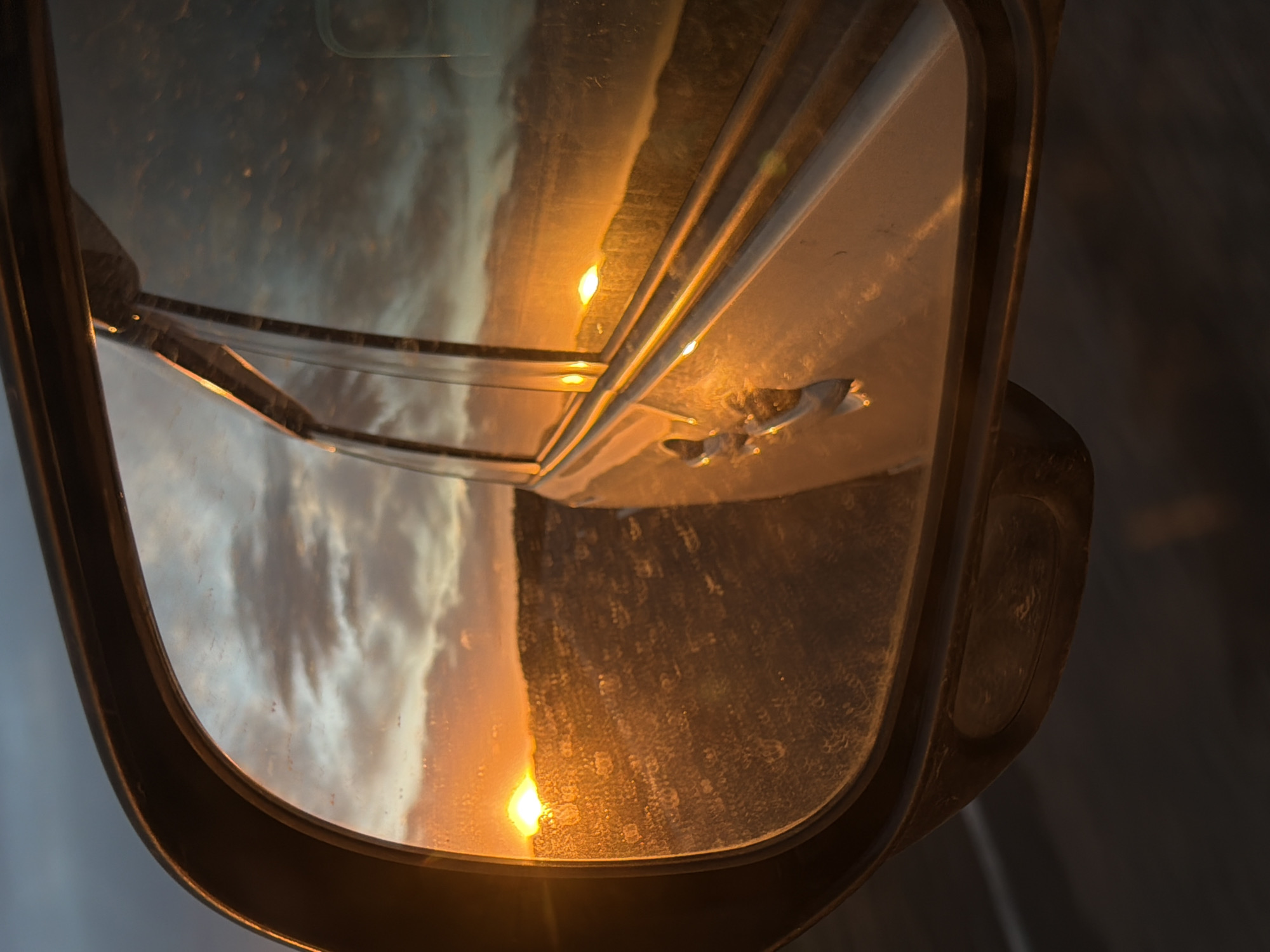 Vehicle mirror reflects sunset sky in Krasnaya, Russia