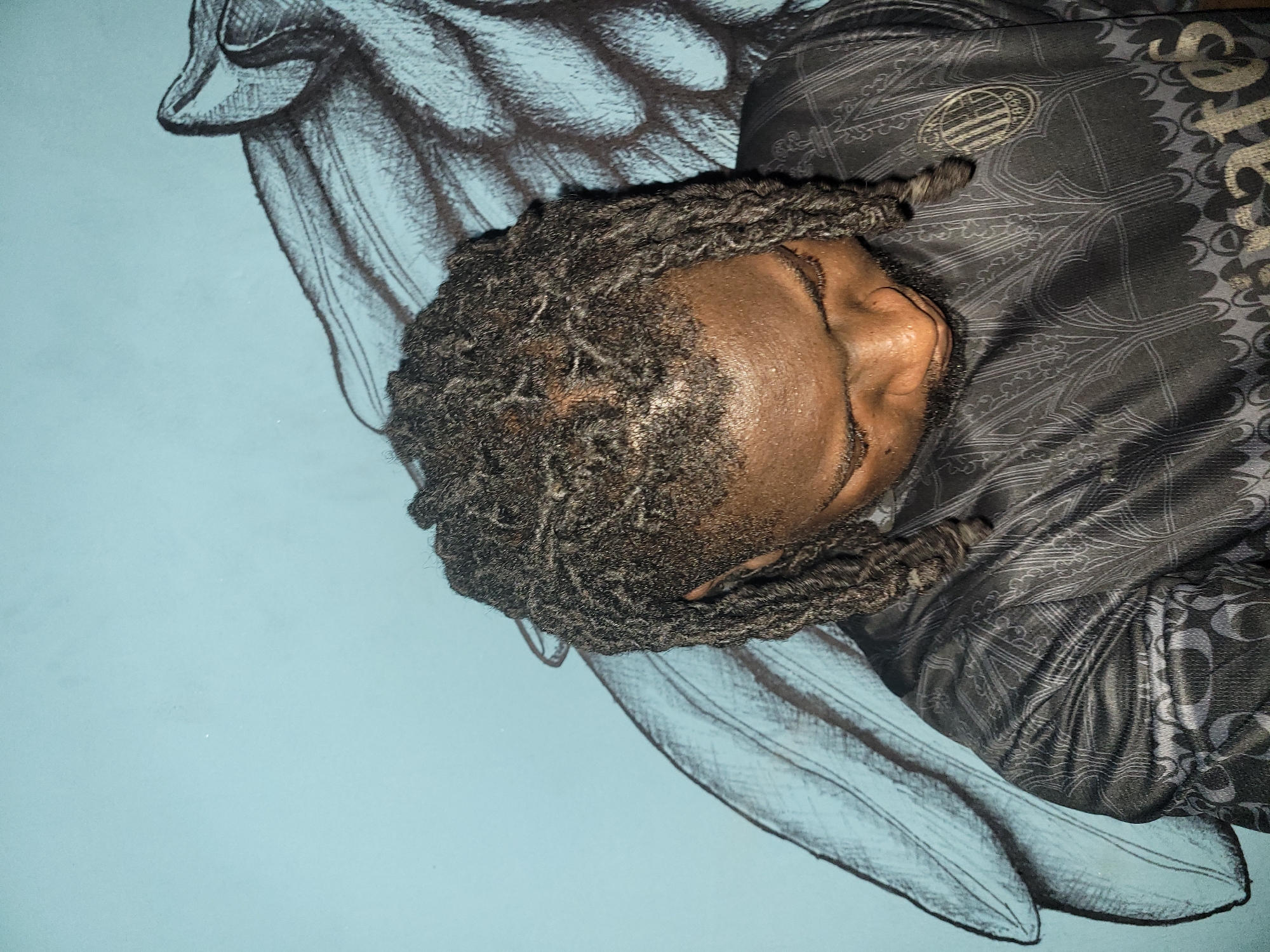 Person rests near wing artwork in Markurdi indoor space