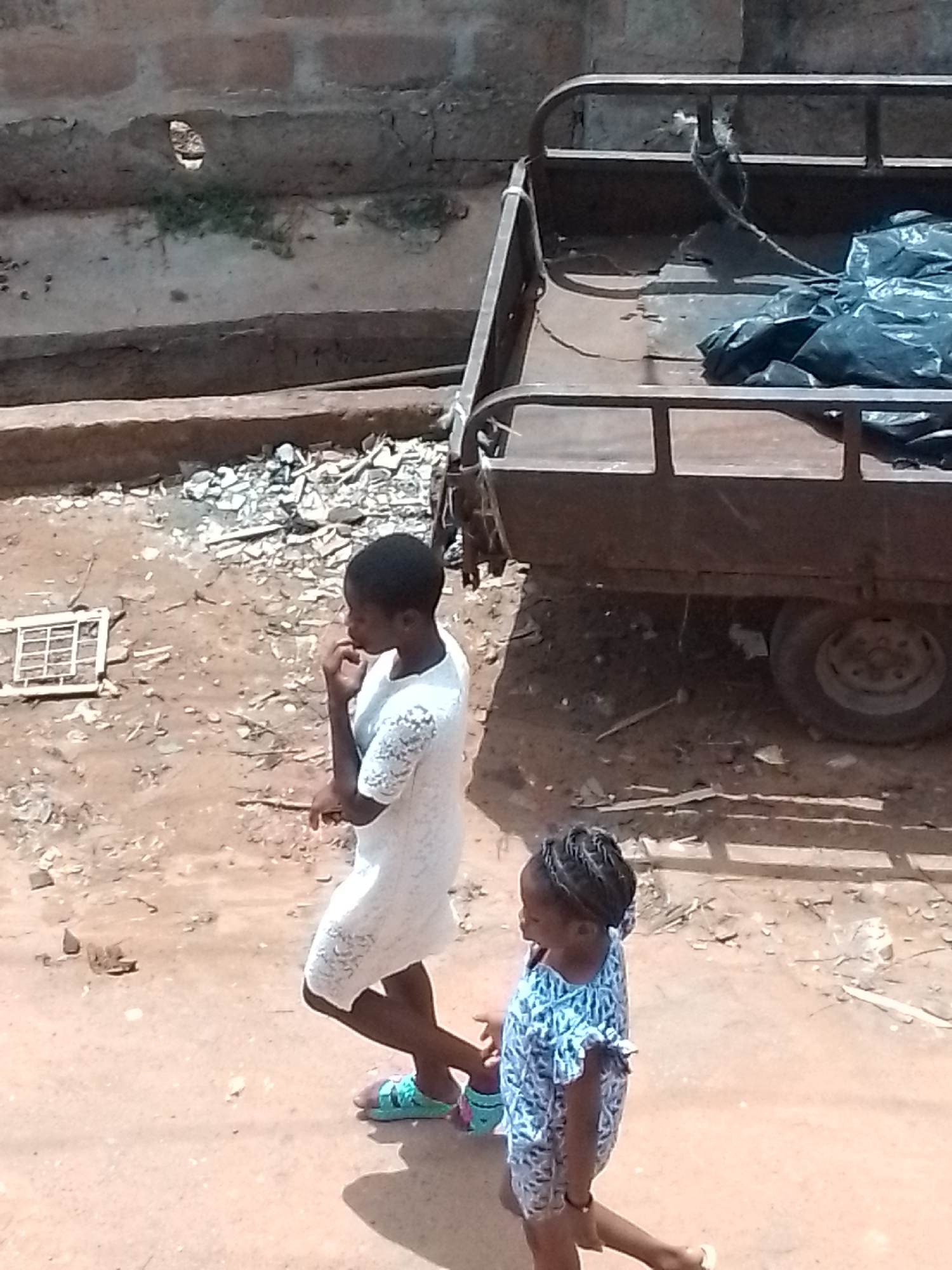 Pedestrians navigate dirt streets in urban area