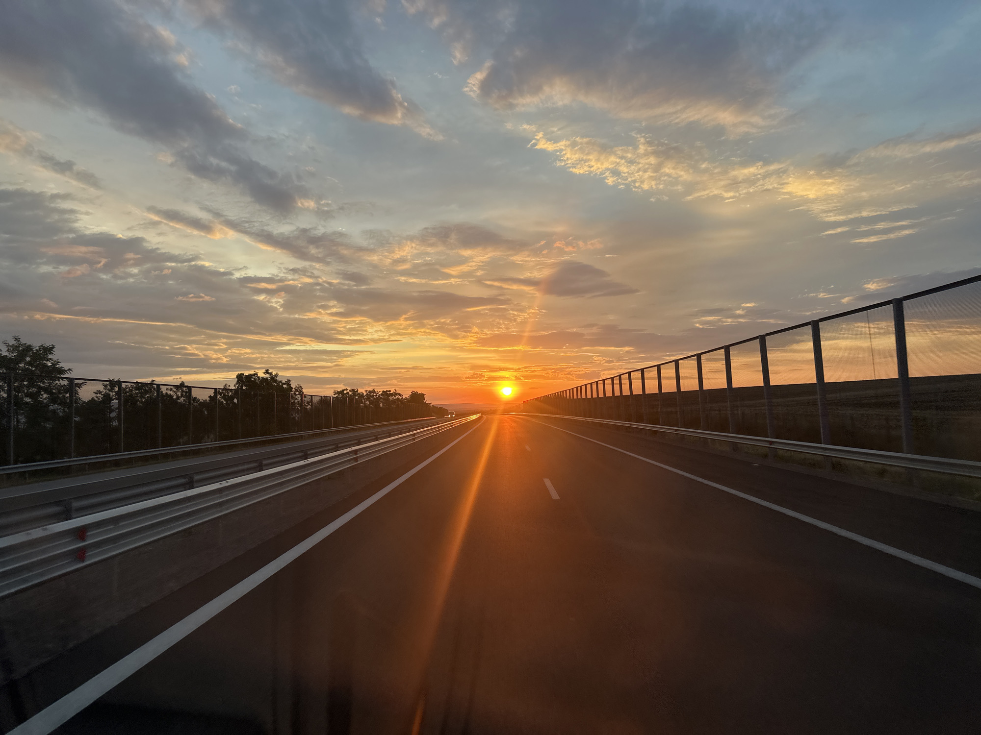 Empty Bulgarian highway glows under a July sunset
